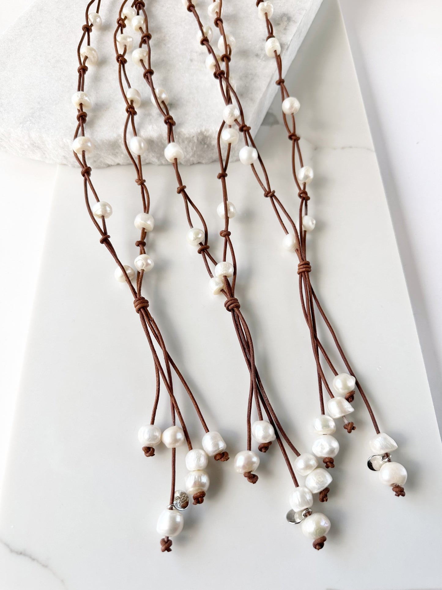 Three White Freshwater Pearl Necklaces on Tan Leather