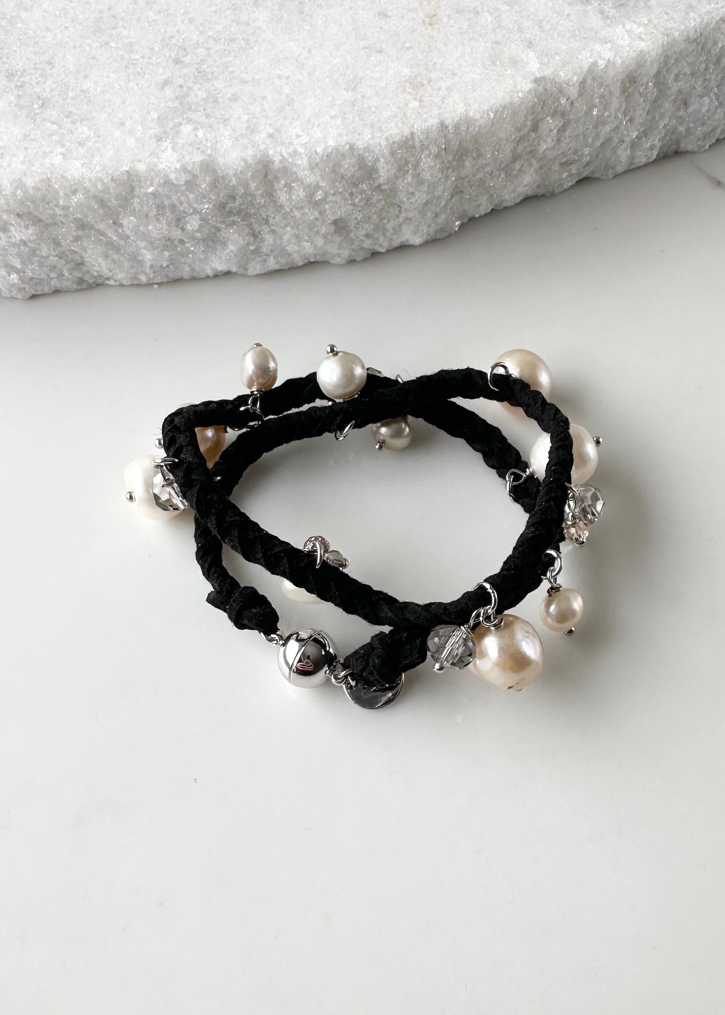 White and Champagne Baroque, Freshwater Pearls hang from this 14” Double Wrap Bracelet made of Vegan Suede in Black.  The piece is completed with crystal accents and a Strong Secure Magnetic Clasp for Easy Wear.