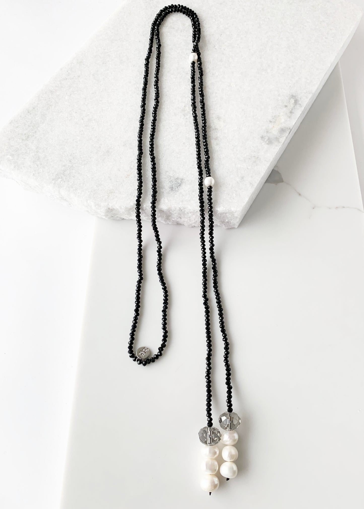 Long, 64-inch Lariat-Style Necklace with Black Crystals and White Freshwater Pearls.  This Versatile piece allows it to be worn in many ways.