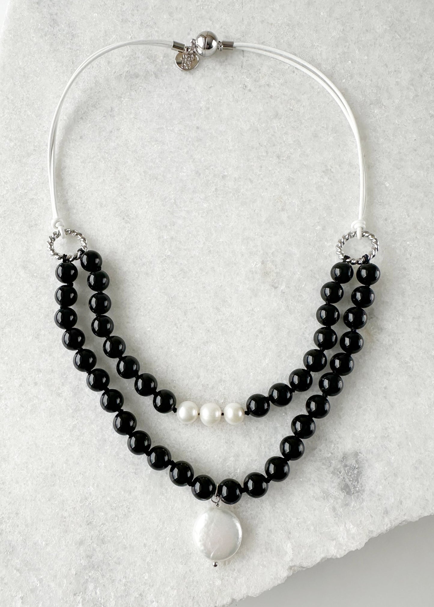 White Freshwater and Coin Pearl Drop on Two Strand Necklace with Black Agate and White Leather.  A strong secure Magnetic Clasp Allows for Easy Wear.