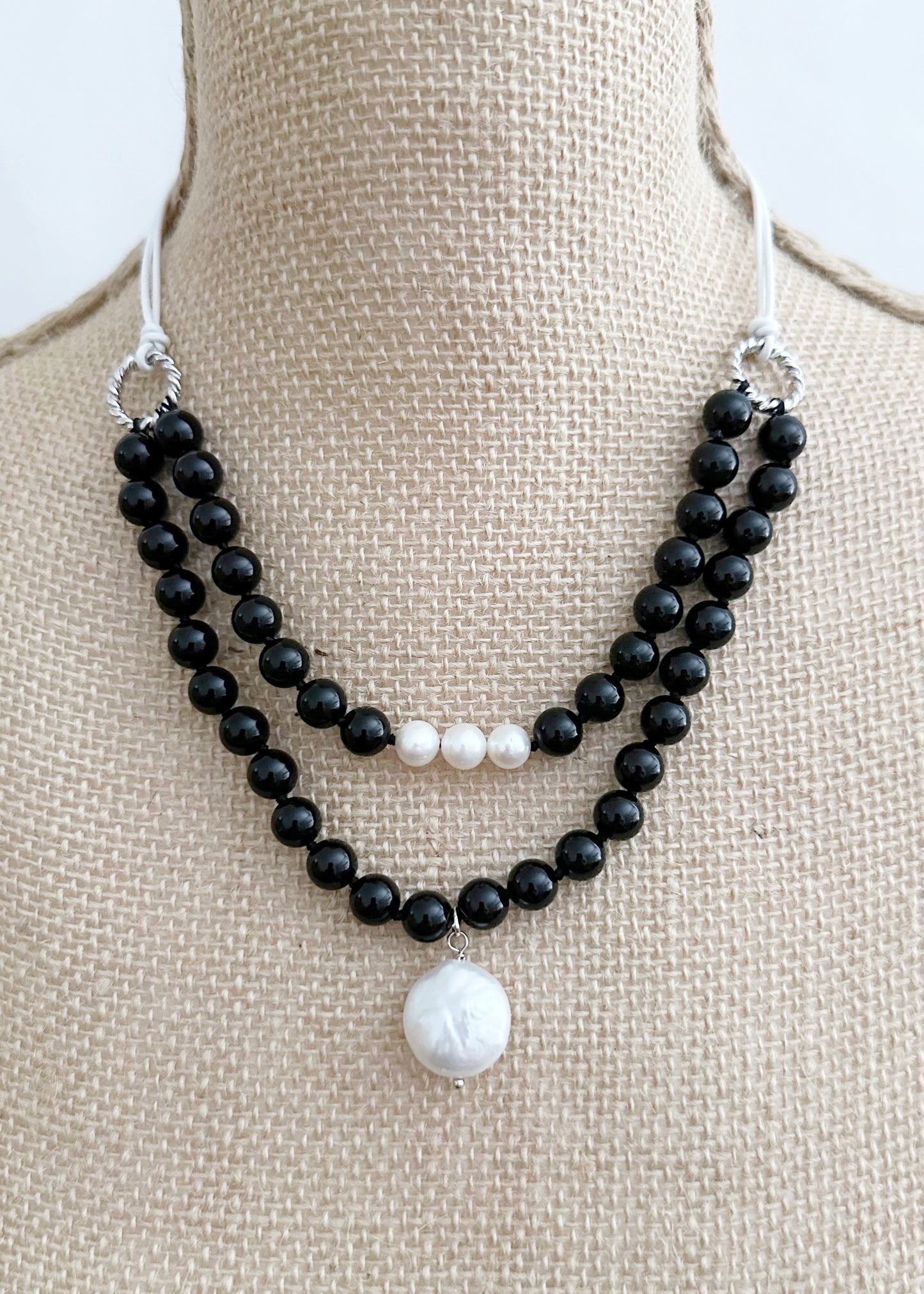 White Freshwater and Coin Pearl Drop on Two Strand Necklace with Black Agate and White Leather.  A strong secure Magnetic Clasp Allows for Easy Wear. On Bust