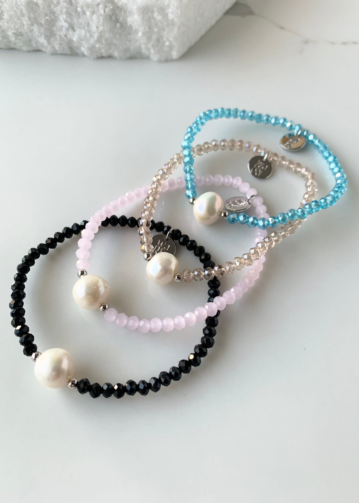 Shown Are All Four Colors of Faceted Crystal Bracelet with Large White Pearl Centered between two Silver Beads.