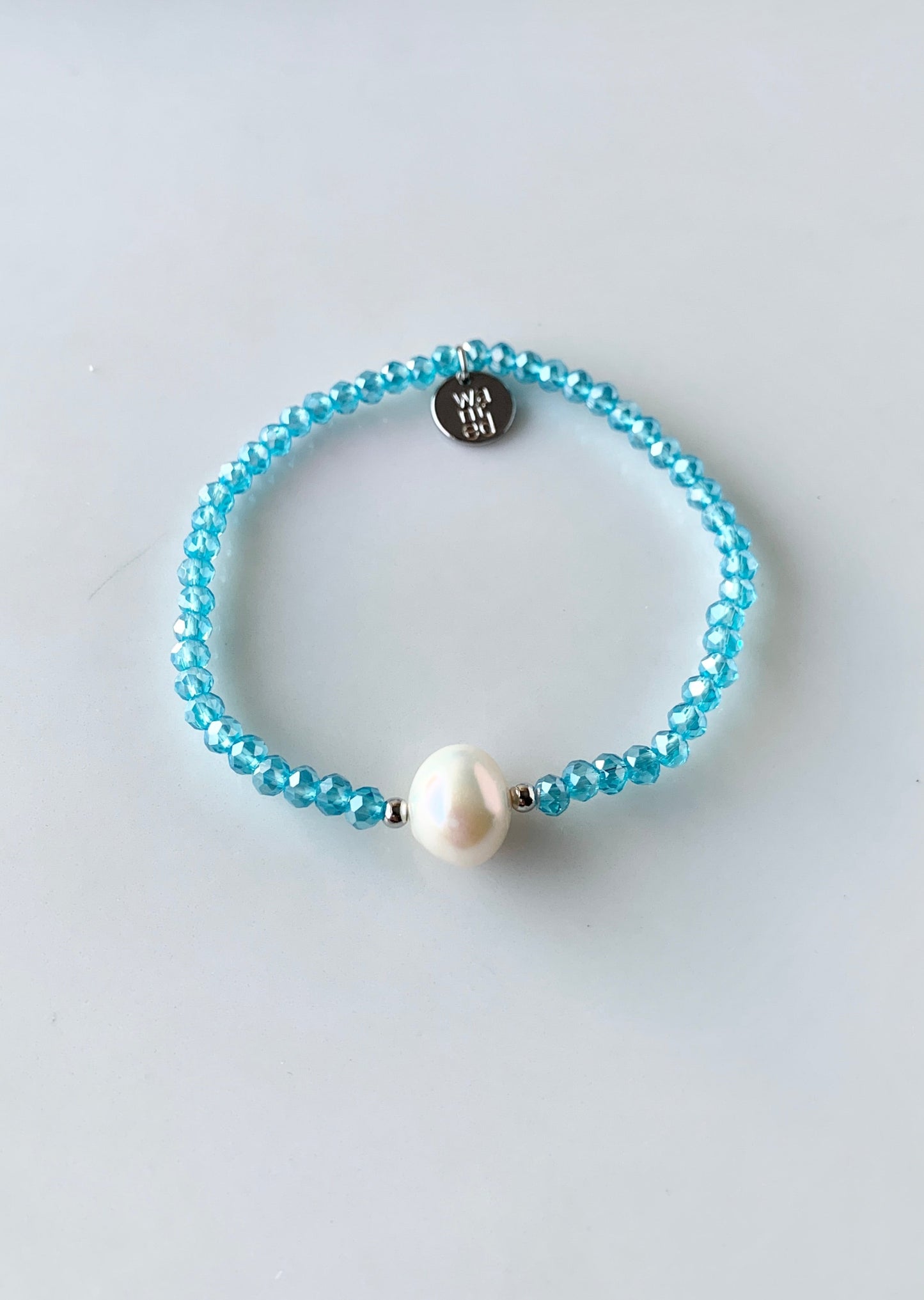 Blue Faceted Crystal Bracelet with Large White Pearl Centered between two Silver Beads.