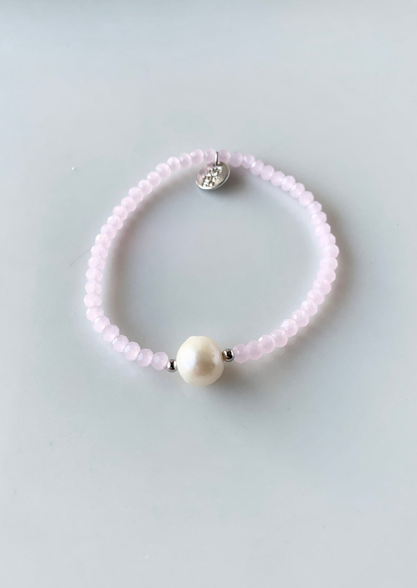 Pink Faceted Crystal Bracelet with Large White Pearl Centered between two Silver Beads.