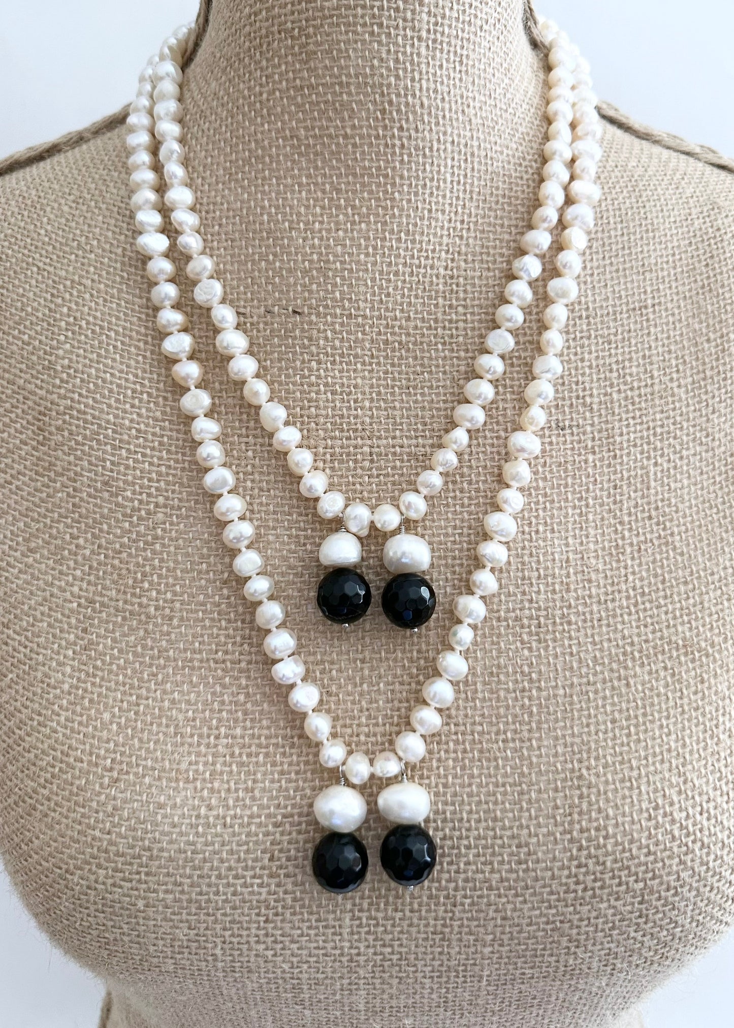 Long Generous White Freshwater Pearl Necklace with Larger Pearl and Black Agate drops.  Can be worn in many Styles. On Bust