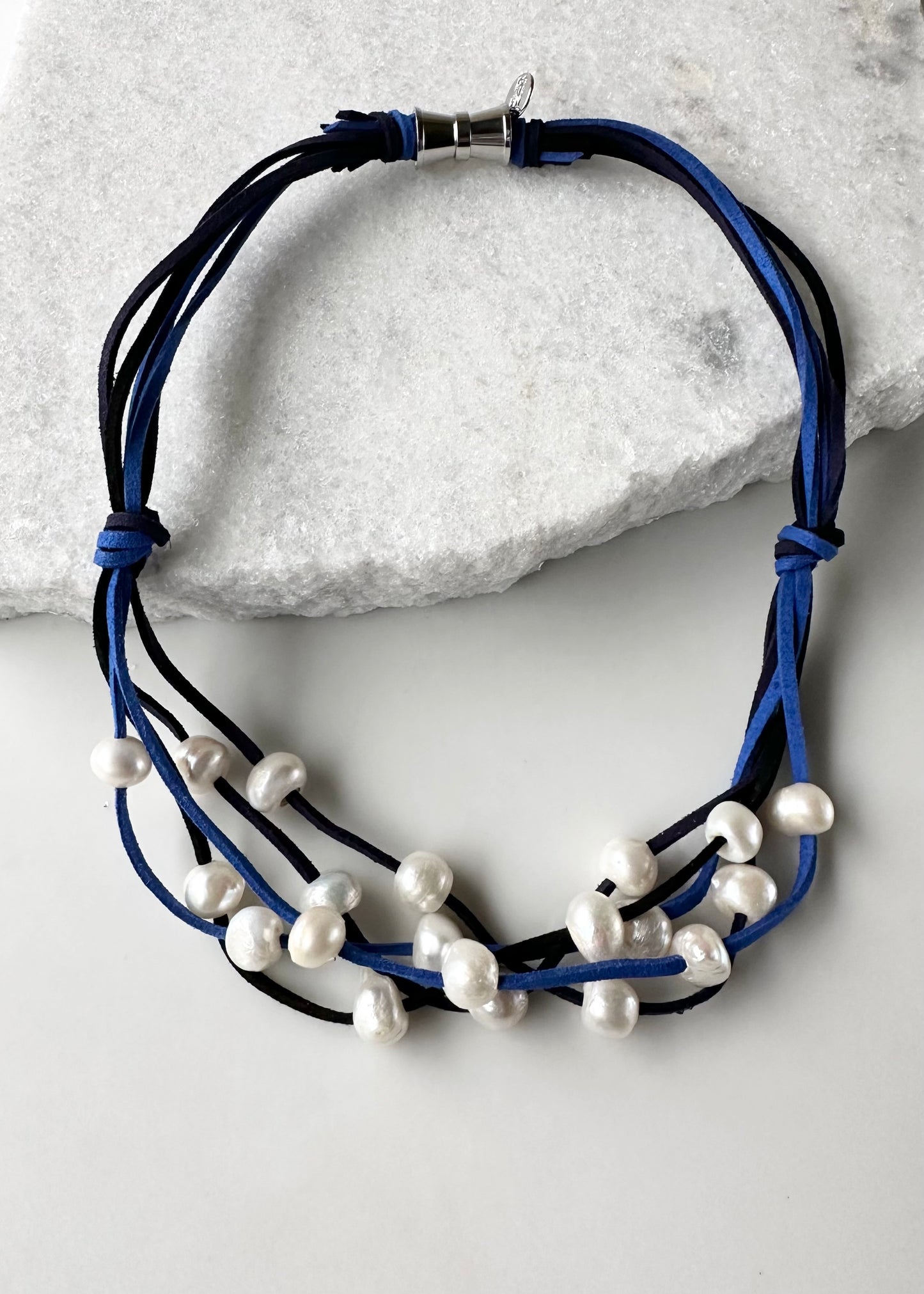 Five Strands of Blue and Black Vegan Suede with Floating White Freshwater Pearls are Offered with a Strong Secure Magnetic Clasp for Easy Wear.