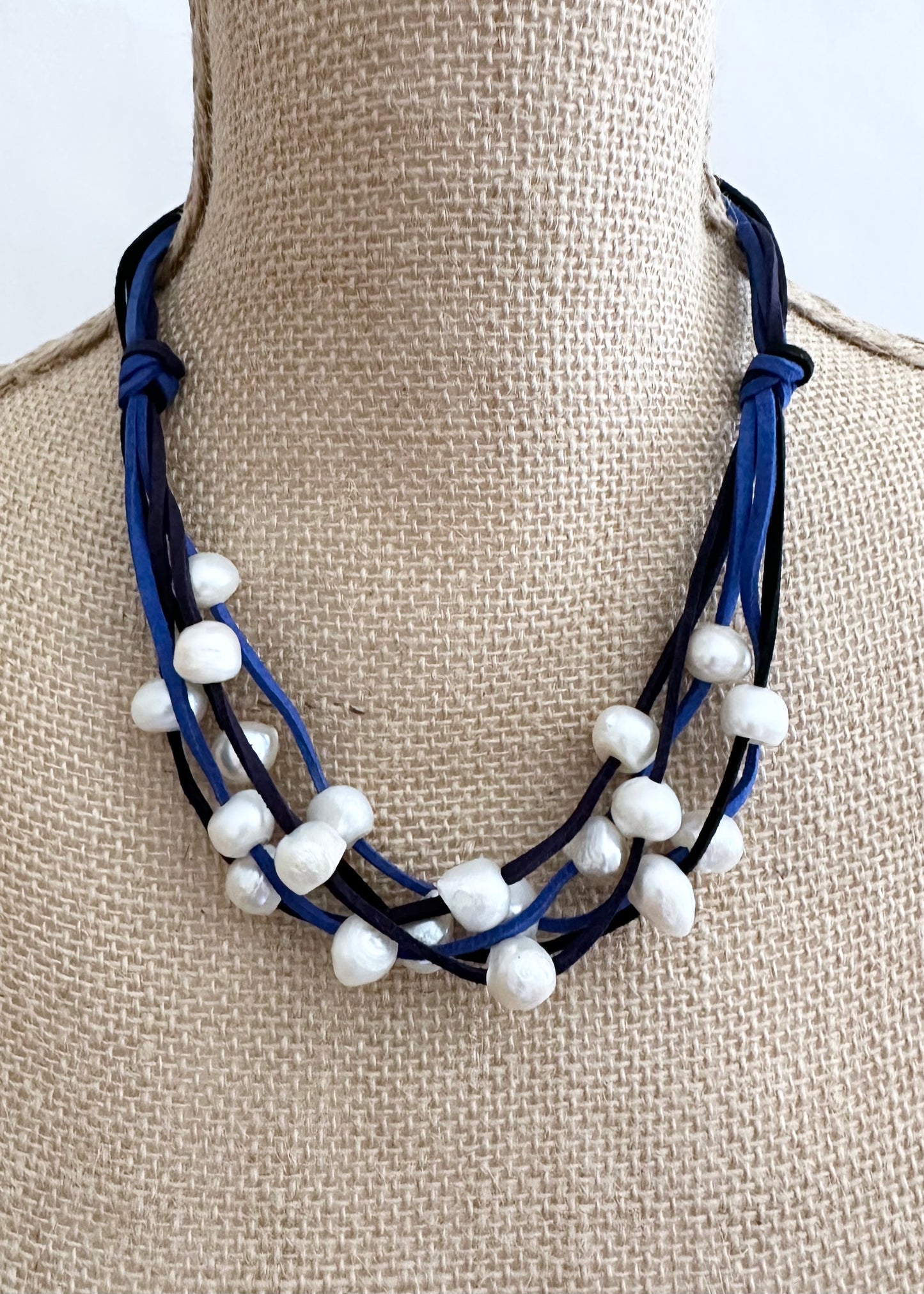 Five Strands of Blue and Black Vegan Suede with Floating White Freshwater Pearls are Offered with a Strong Secure Magnetic Clasp for Easy Wear. On Bust