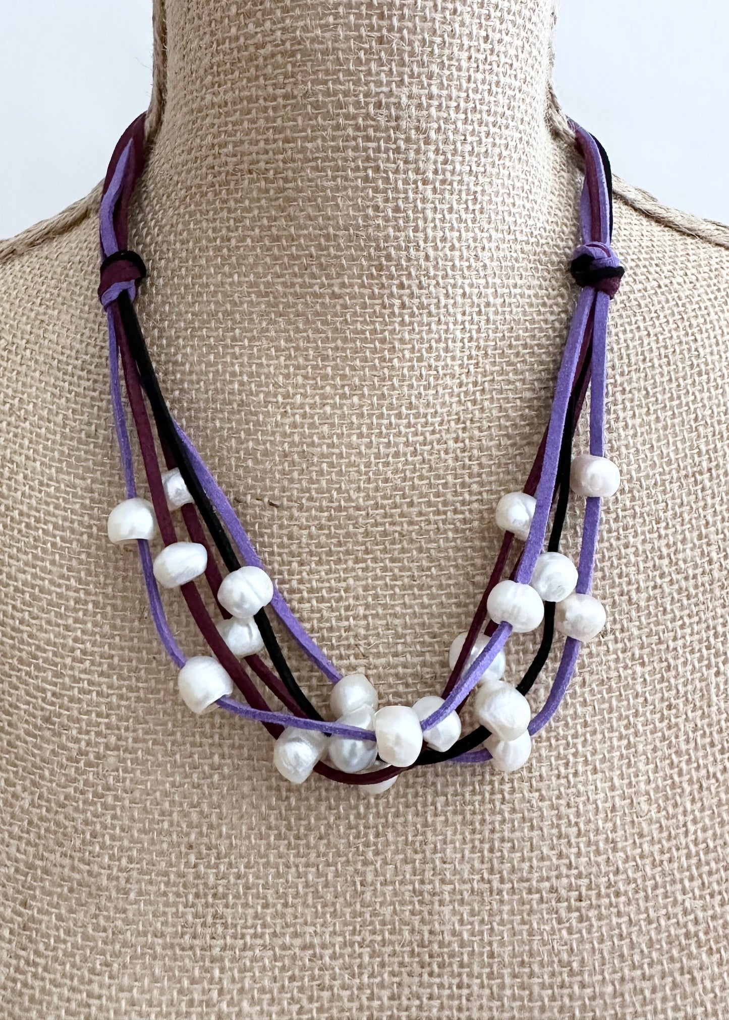 Five Strands of Purple Vegan Suede with Floating White Freshwater Pearls are Offered with a Strong Secure Magnetic Clasp for Easy Wear.