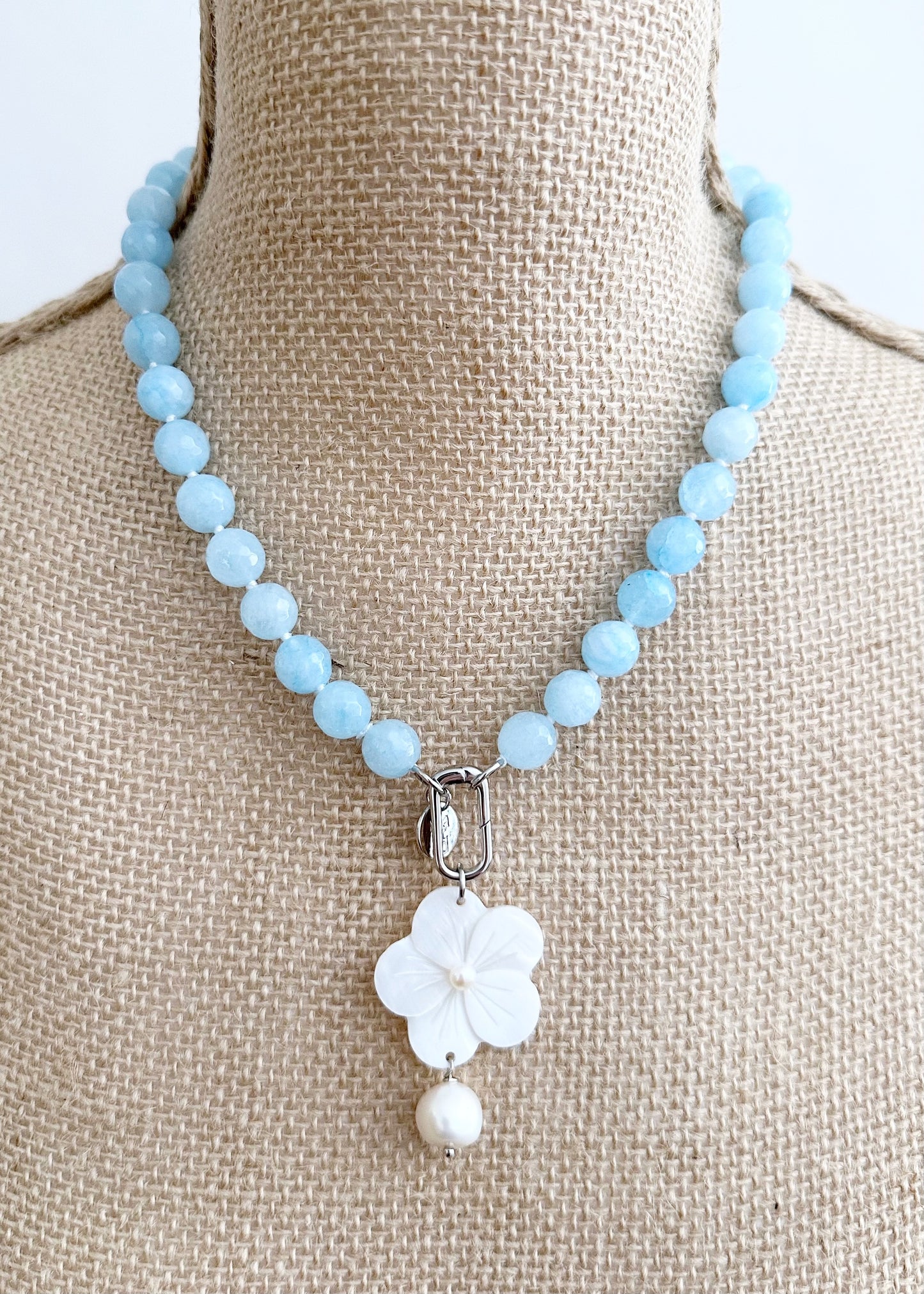 White Freshwater Baroque Pearls Strung with Faceted Blue Semi-Precious Stones with a Pretty Carved Shell Flower Pendant Hanging from a Gold-Plated Rectangular Clasp for a 18.5” Necklace.  This Necklace can be worn in Various ways.