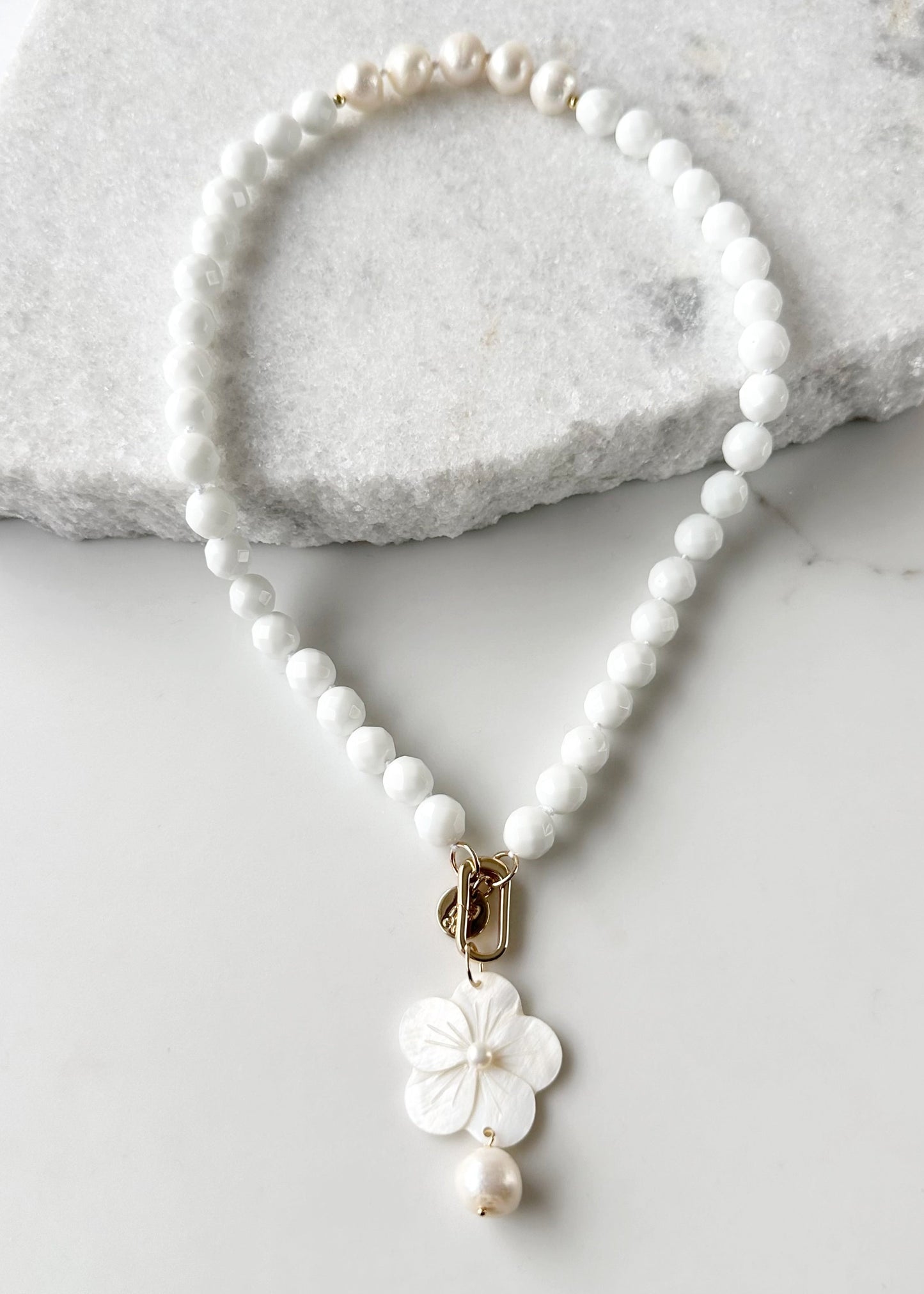 White Freshwater Baroque Pearls Strung with Faceted White Semi-Precious Stones with a Pretty Carved Shell Flower Pendant Hanging from a Gold-Plated Rectangular Clasp for a 18.5” Necklace.  This Necklace can be worn in Various ways.