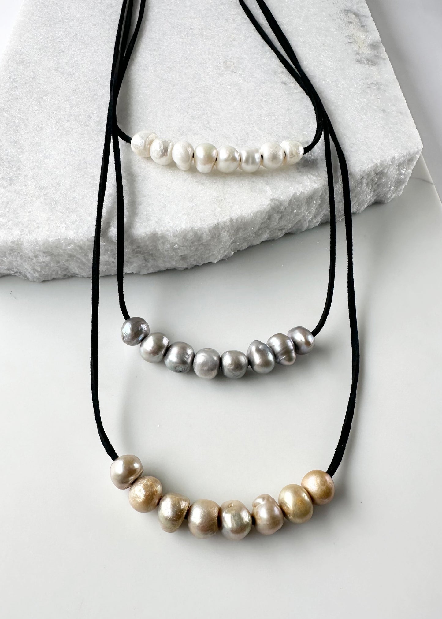 Three Strands of Black Vegan Suede with Floating White Silver and Gold Freshwater Pearls Completed with a Strong Secure Magnetic Clasp for Easy Wear. Magnified