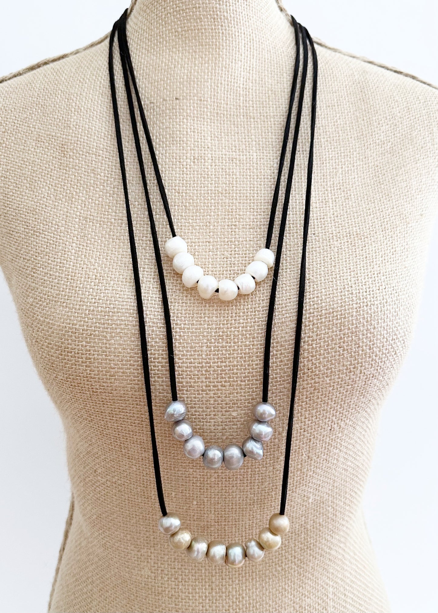 Three Strands of Black Vegan Suede with Floating White Silver and Gold Freshwater Pearls Completed with a Strong Secure Magnetic Clasp for Easy Wear. On Bust