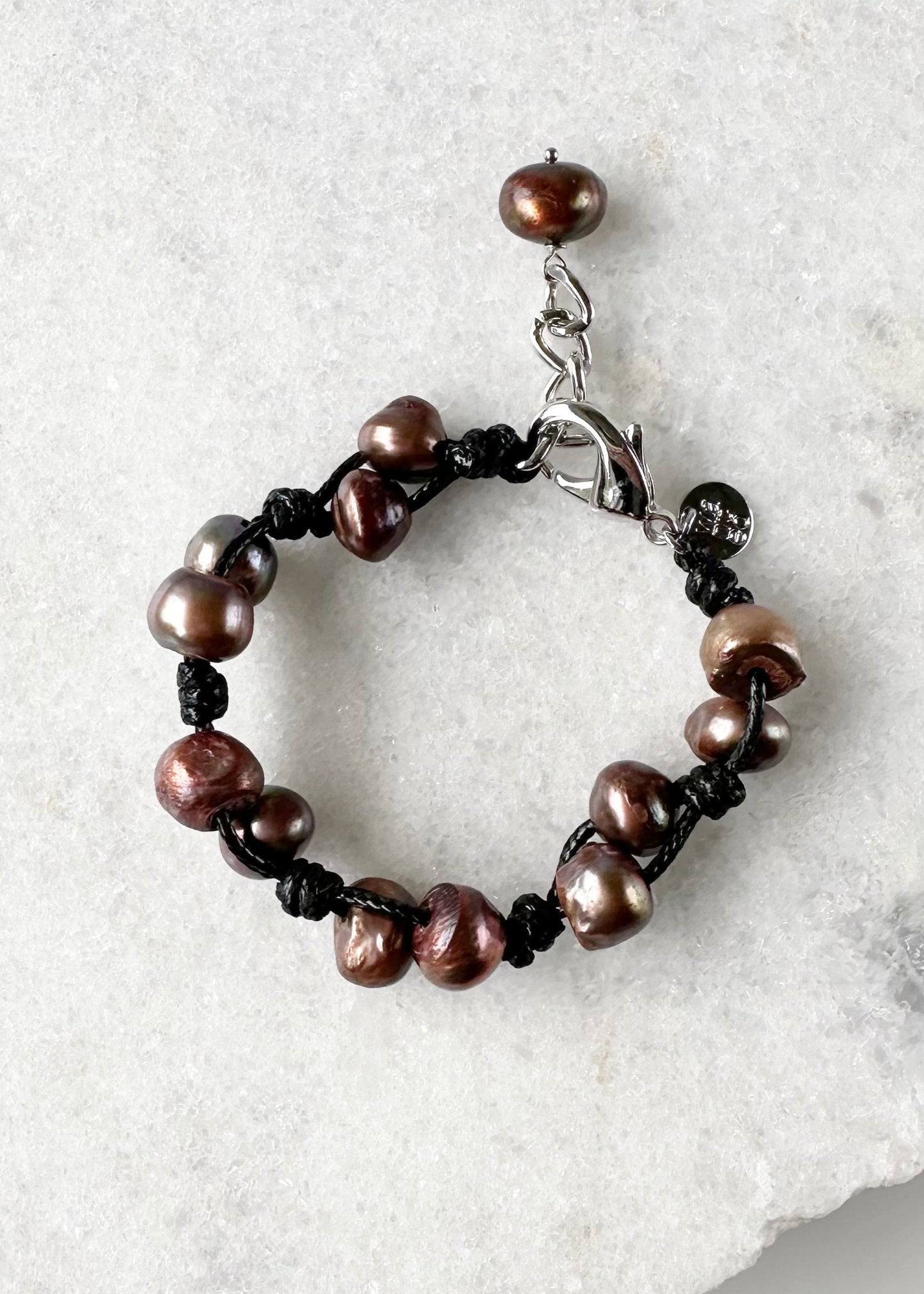 This 7.5” Bracelet Features Lustrous Freshwater Pearls Knotted on Cotton Cord,  Completed with a Large Lobster Claw Clasp and Extender Chain. Designed in Canada.