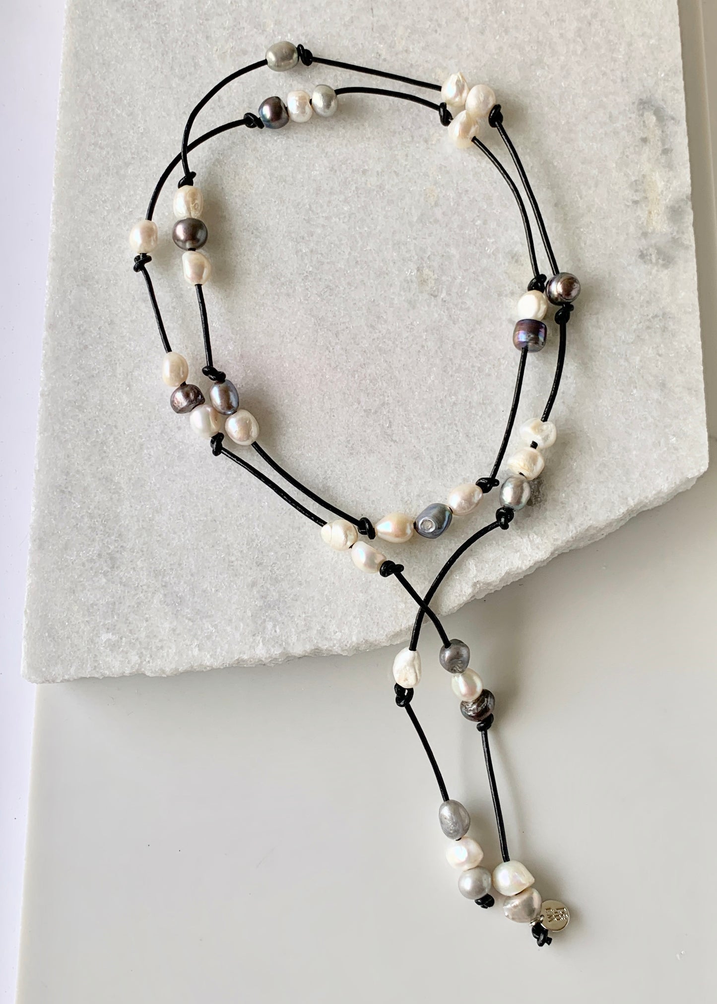 Long 46” Black Leather Lariat Adorned with Lustrous Mixed Freshwater Pearls.  Can be worn Long, Doubled and in a Variety of Ways to Suit your Personal Taste and Mood.