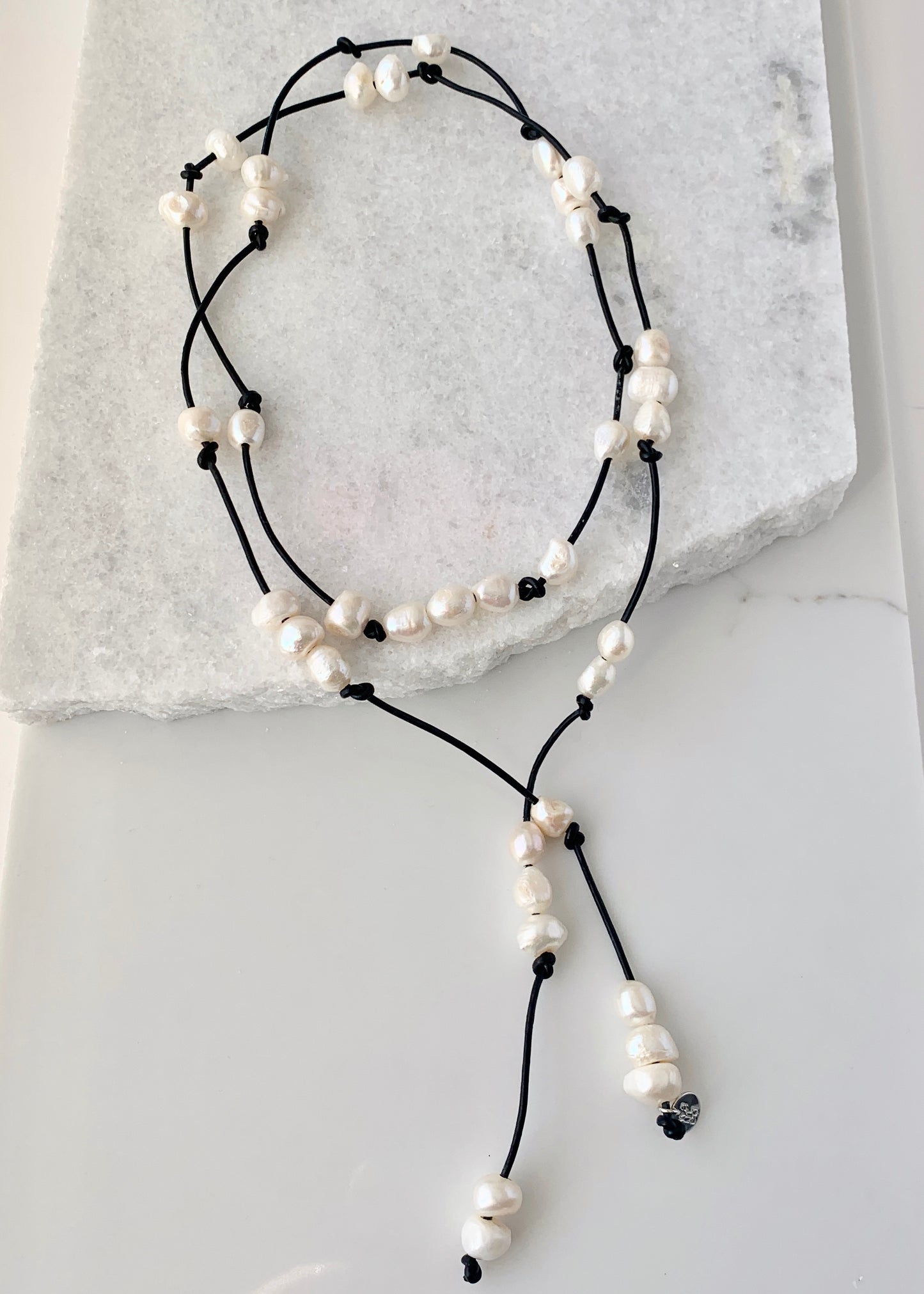 Long 46” Black Leather Lariat Adorned with Lustrous White Freshwater Pearls.  Can be worn Long, Doubled and in a Variety of Ways to Suit your Personal Taste and Mood.