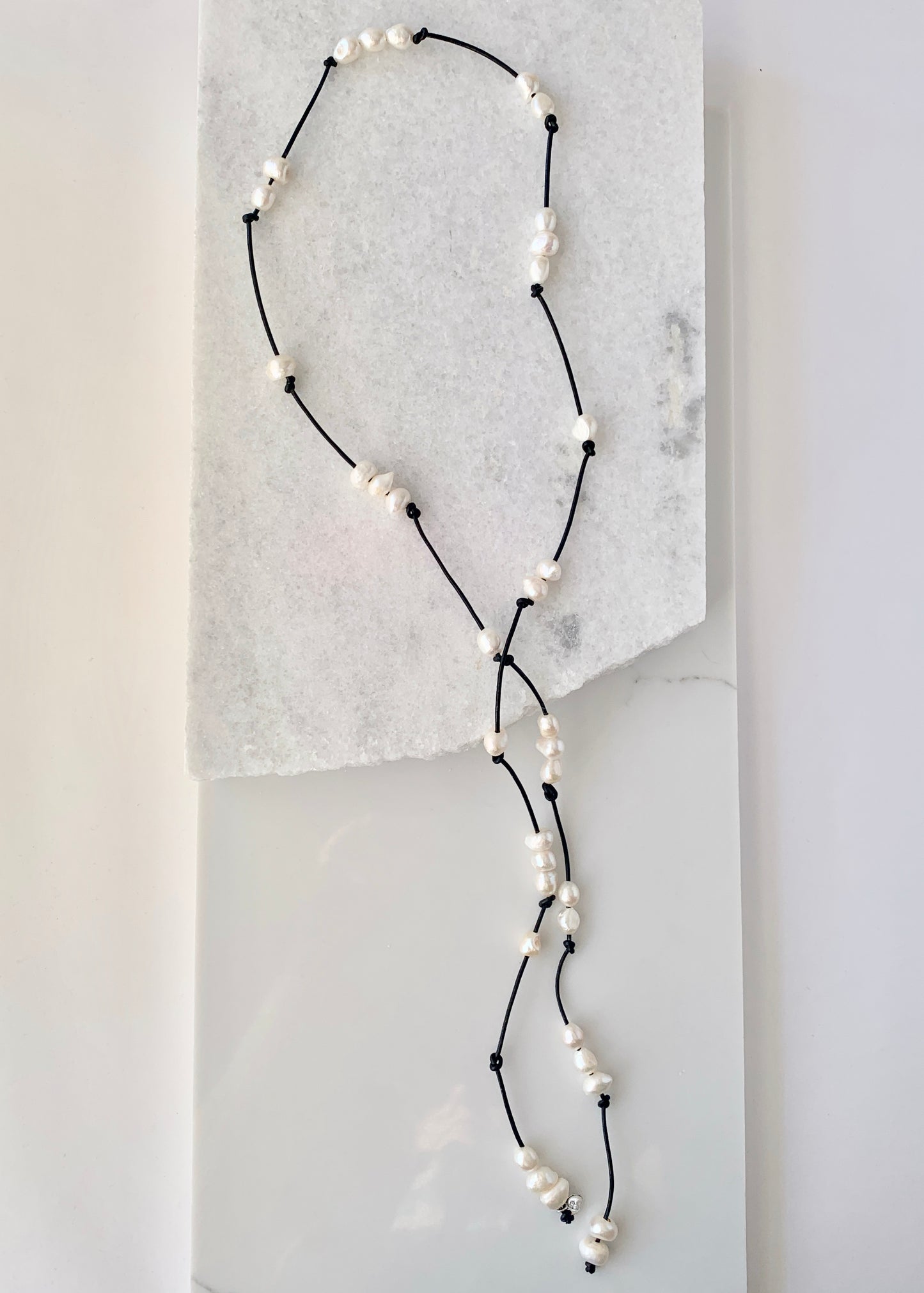 Long 46” Black Leather Lariat Adorned with Lustrous White Freshwater Pearls.  Can be worn Long, Doubled and in a Variety of Ways to Suit your Personal Taste and Mood. Focus on 46