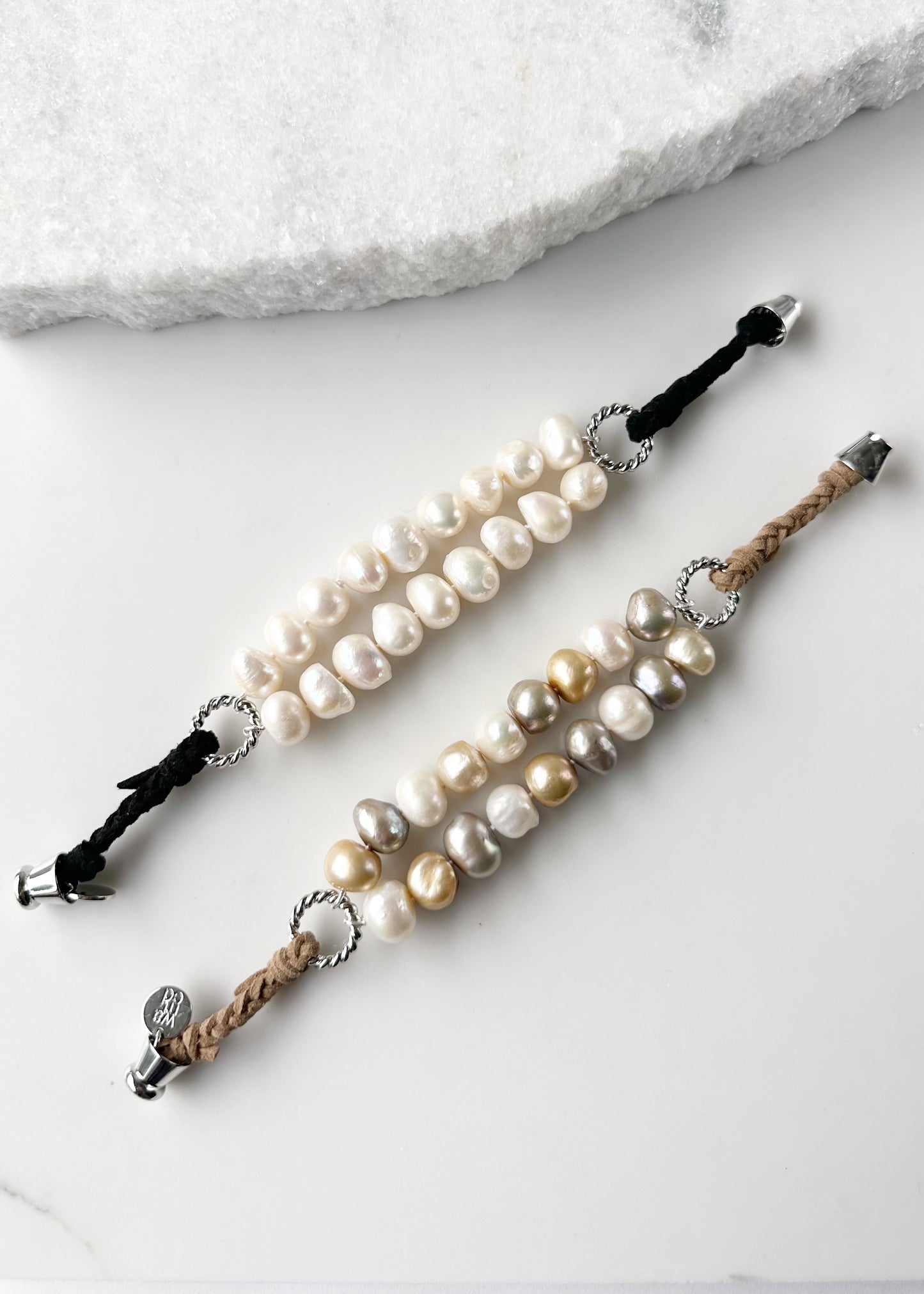 This 8” Bracelet has Two Knotted Strands of Large Freshwater Pearls with Braided Vegan Suede Accented with Silver Rings and a Magnetic Clasp. Designed in Canada