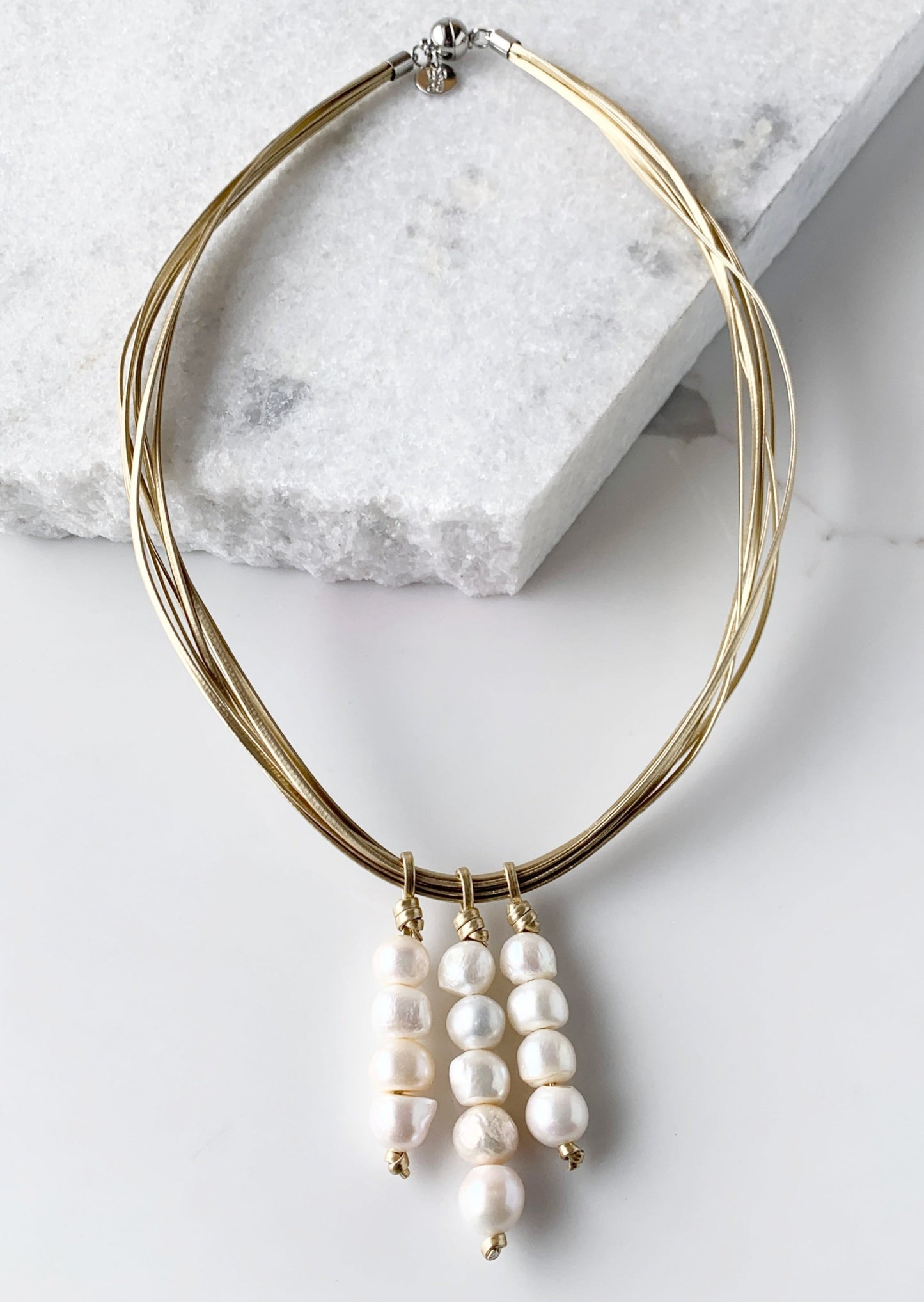 Three Stacks of White Baroque Freshwater Pearls on Gold Metal Cord Make Up this Necklace with a Strong Secure Magnetic Clasp for Easy Wear.