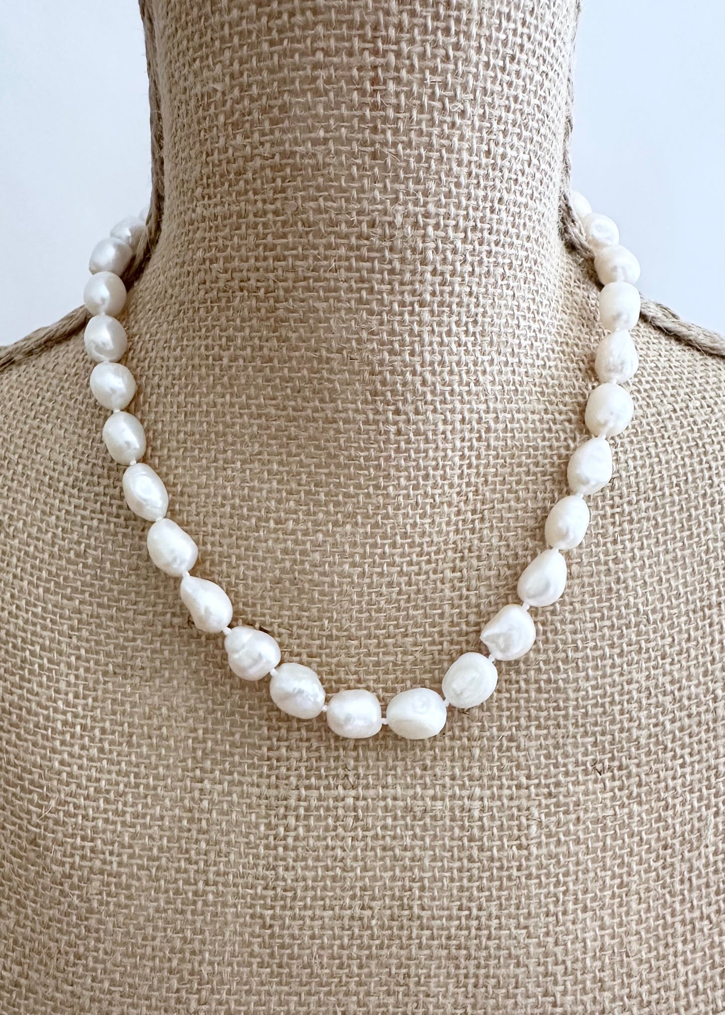 Lustrous Baroque Freshwater Pearls are Knotted in White  with a Gold Charm Clasp to Place your Favorite Pendants.  And Wear the 18.5” Necklace in Reverse to show off the Classic Pearls. On Bust