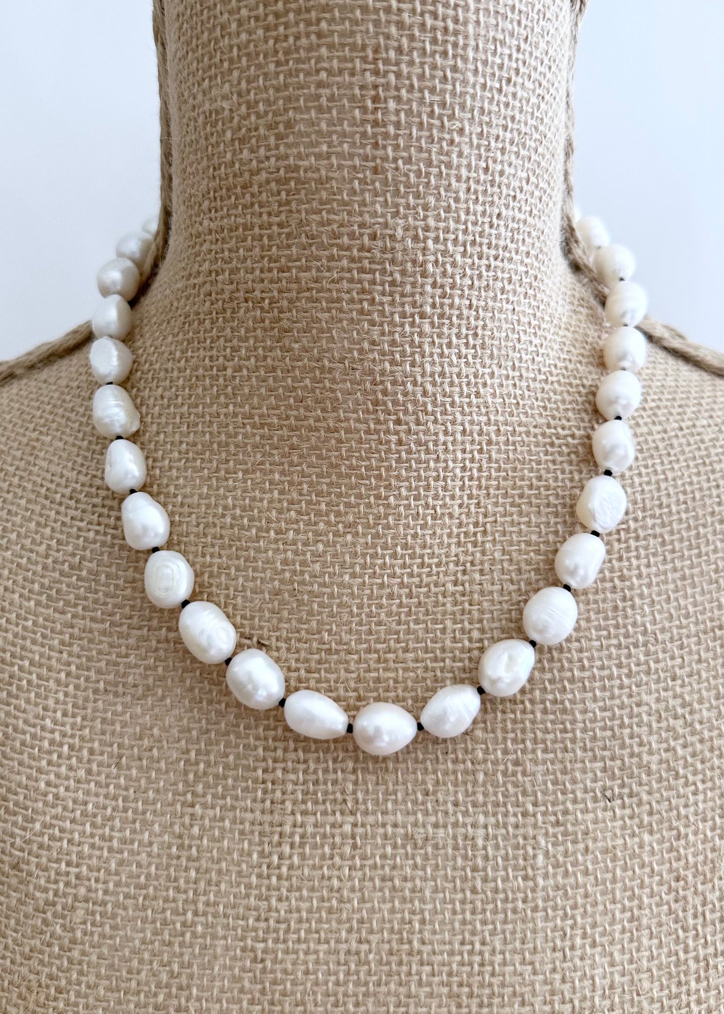 Lustrous Baroque Freshwater Pearls are Knotted in Black with a Silver Charm Clasp to Place your Favorite Pendants.  And Wear the 18.5” Necklace in Reverse to show off the Classic Pearls. On Bust