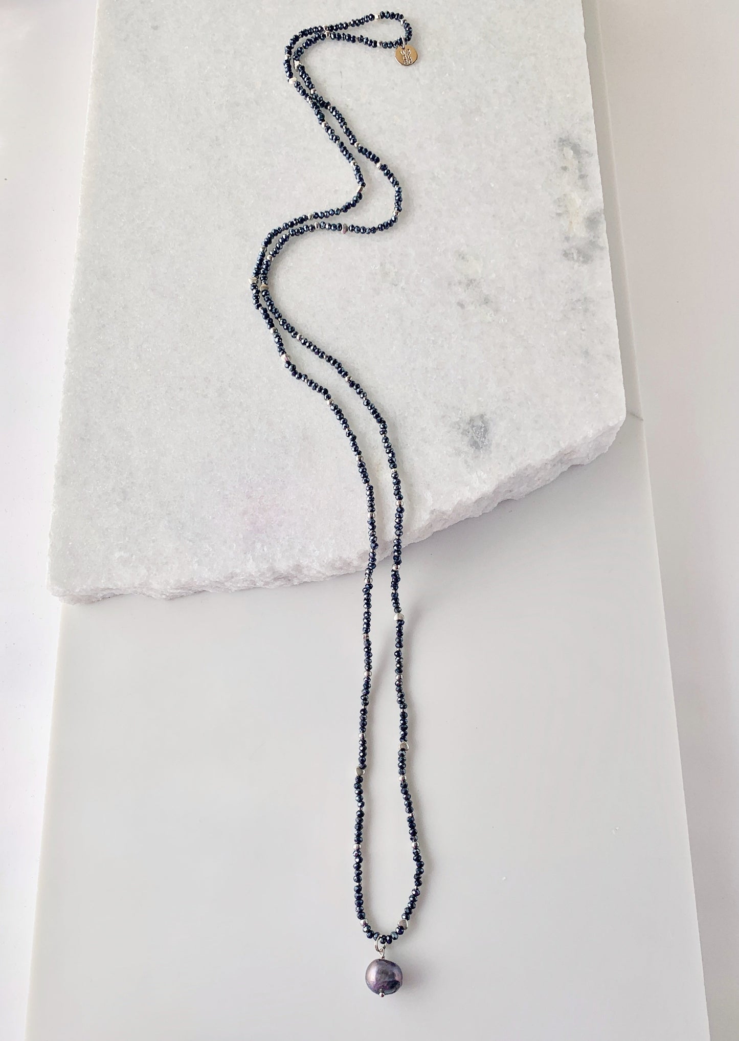 A White Freshwater Pearl Drop falls from this 21” Necklace of Delicate 2mm Navy Crystals and Silver Beads with No Clasp.  Great for Layering with Other Favorites.