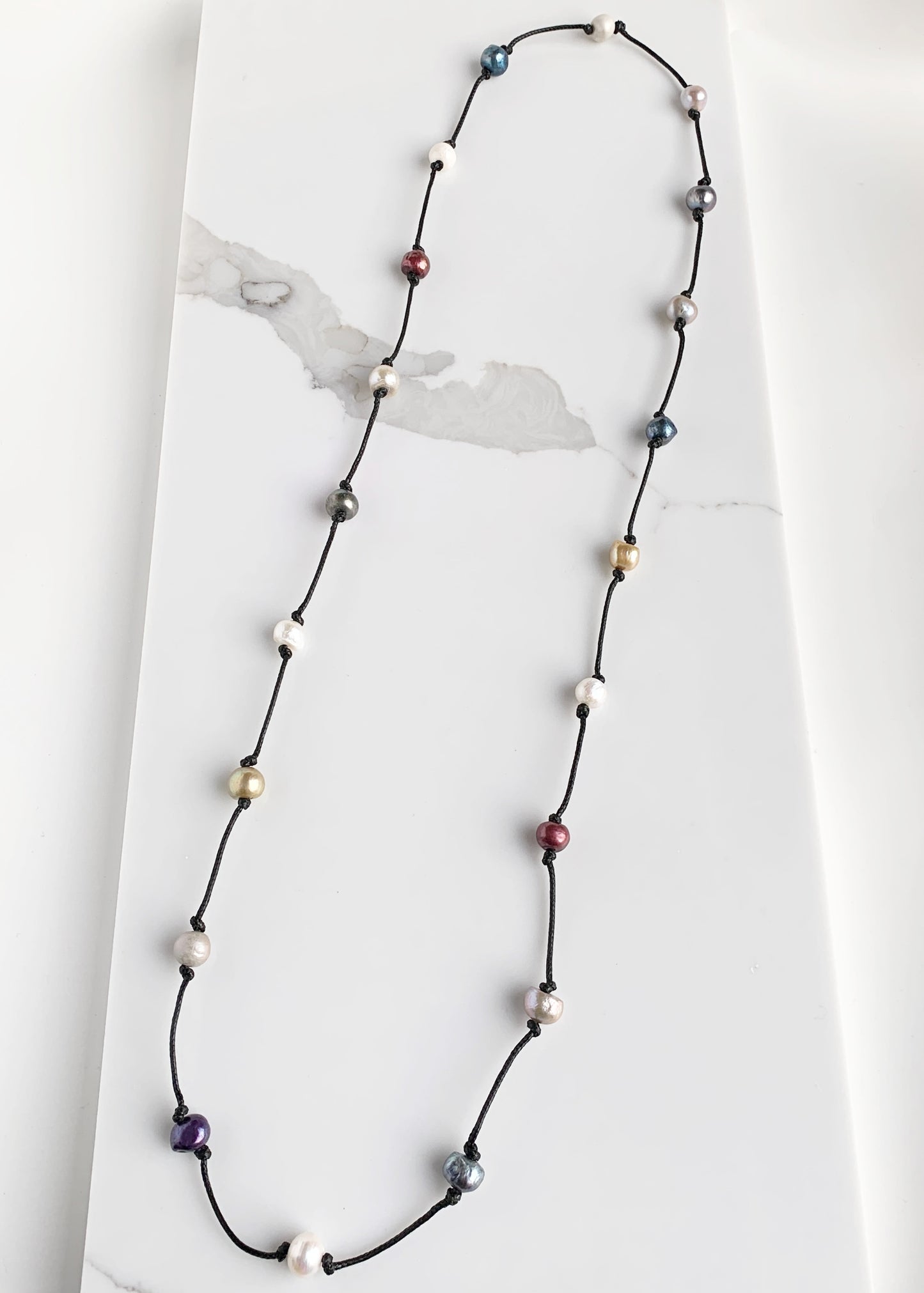 Lustrous Multi-Colored Freshwater Pearls Knotted on Black Cotton in this 21” Necklace.