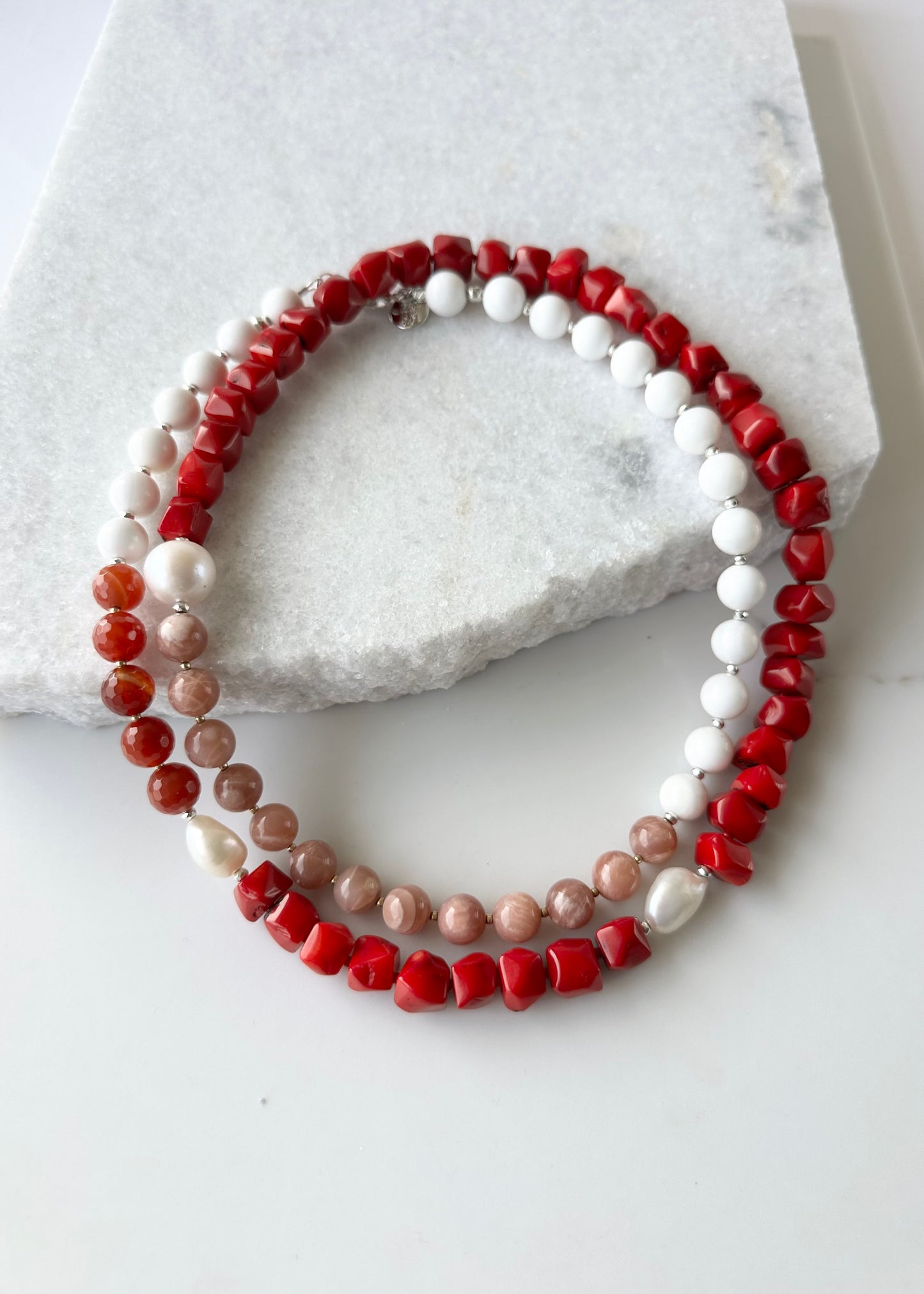This 38” Long and Beautiful Necklace Boasts a Rich Blend of Colours including Vibrant Red Sea Bamboo, Soft Peach Moonstone, Faceted Carnelian, Crisp White Agate and Elegant White Freshwater Pearls.  The Necklace is finished with Gold and Silver Beads and a Sterling Silver Lobster Claw Clasp and can be Worn Long or Doubled Up.