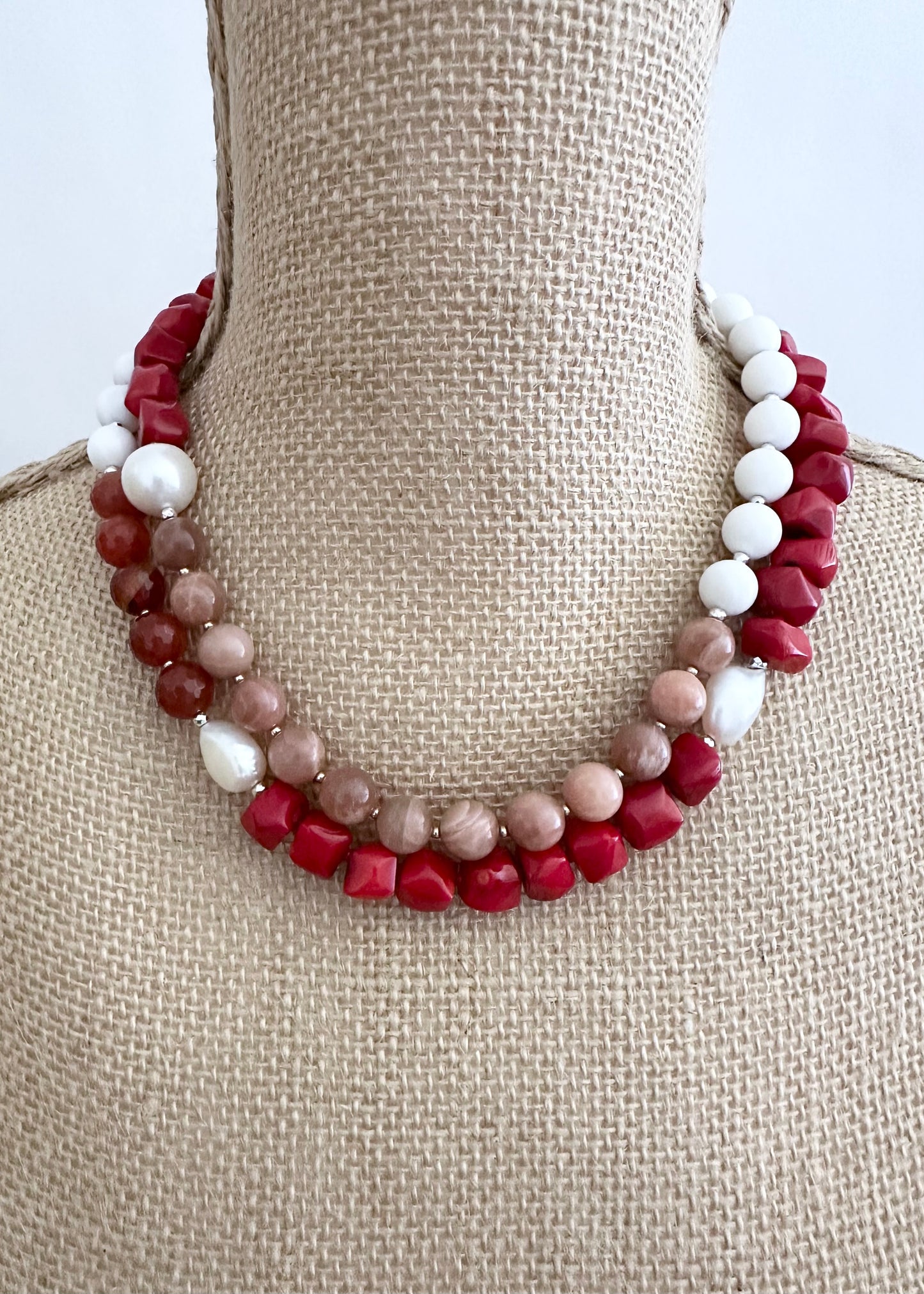 This 38” Long and Beautiful Necklace Boasts a Rich Blend of Colours including Vibrant Red Sea Bamboo, Soft Peach Moonstone, Faceted Carnelian, Crisp White Agate and Elegant White Freshwater Pearls.  The Necklace is finished with Gold and Silver Beads and a Sterling Silver Lobster Claw Clasp and can be Worn Long or Doubled Up.