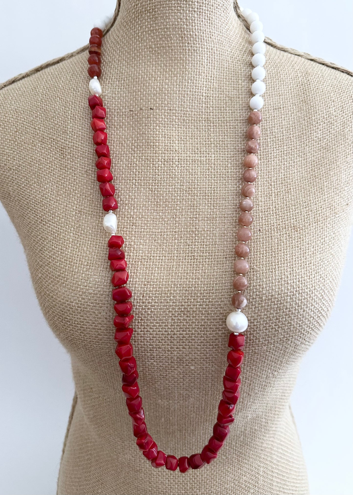 This 38” Long and Beautiful Necklace Boasts a Rich Blend of Colours including Vibrant Red Sea Bamboo, Soft Peach Moonstone, Faceted Carnelian, Crisp White Agate and Elegant White Freshwater Pearls.  The Necklace is finished with Gold and Silver Beads and a Sterling Silver Lobster Claw Clasp and can be Worn Long or Doubled Up.