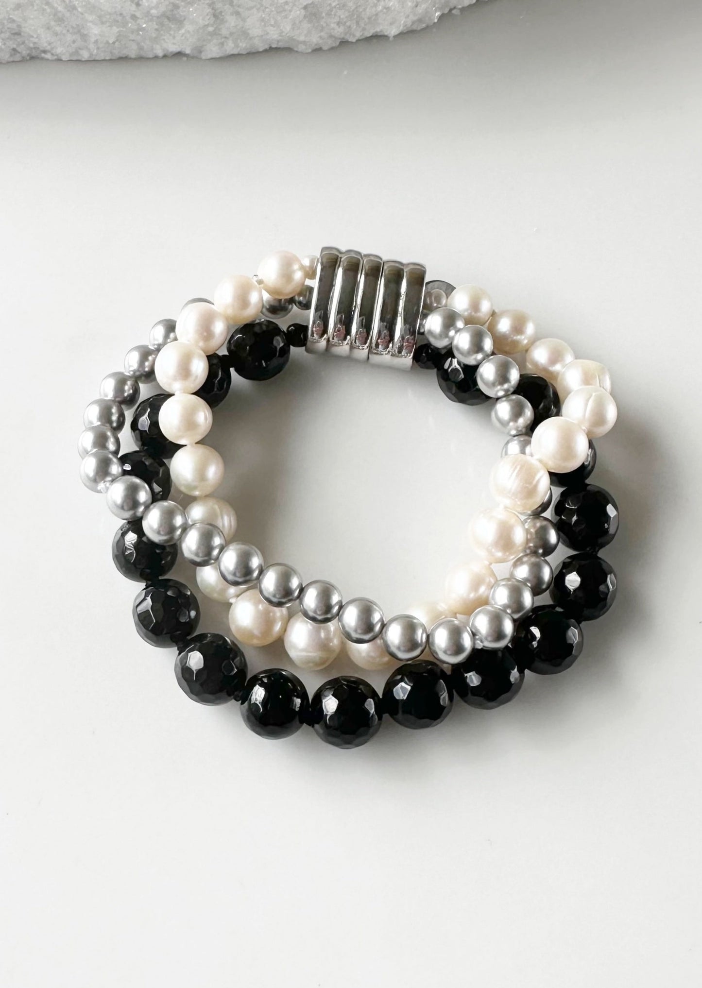 Three Strand Bracelet with White Freshwater Pearls, Black Faceted Agate and Silver Shell Pearls Finished with a Magnetic Clasp for Easy Wear.