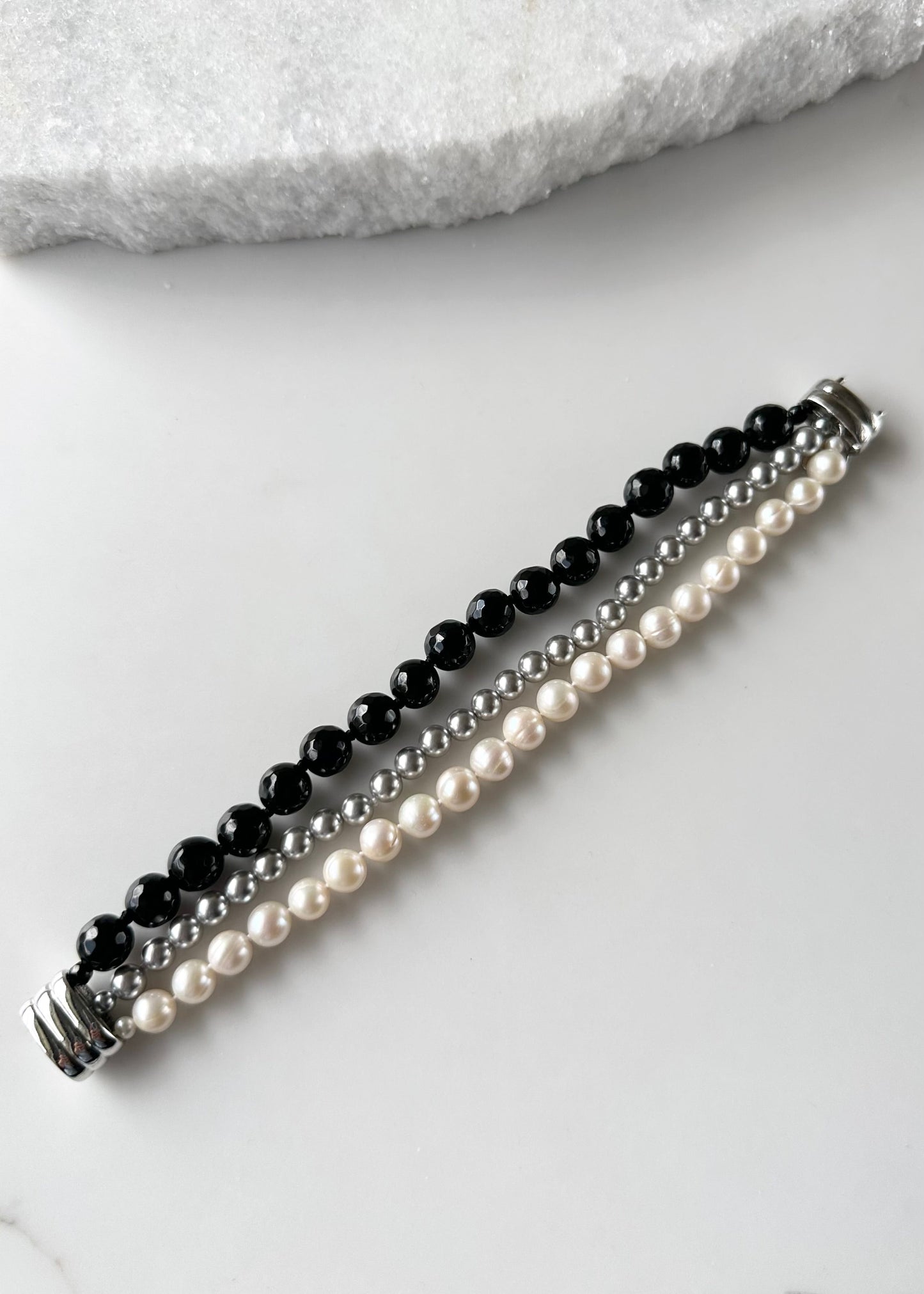 Three Strand Bracelet with White Freshwater Pearls, Black Faceted Agate and Silver Shell Pearls Finished with a Magnetic Clasp for Easy Wear. Length is 7.75