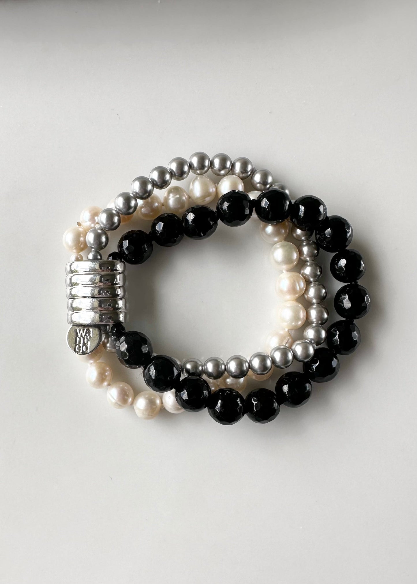 Three Strand Bracelet with White Freshwater Pearls, Black Faceted Agate and Silver Shell Pearls Finished with a Magnetic Clasp for Easy Wear.