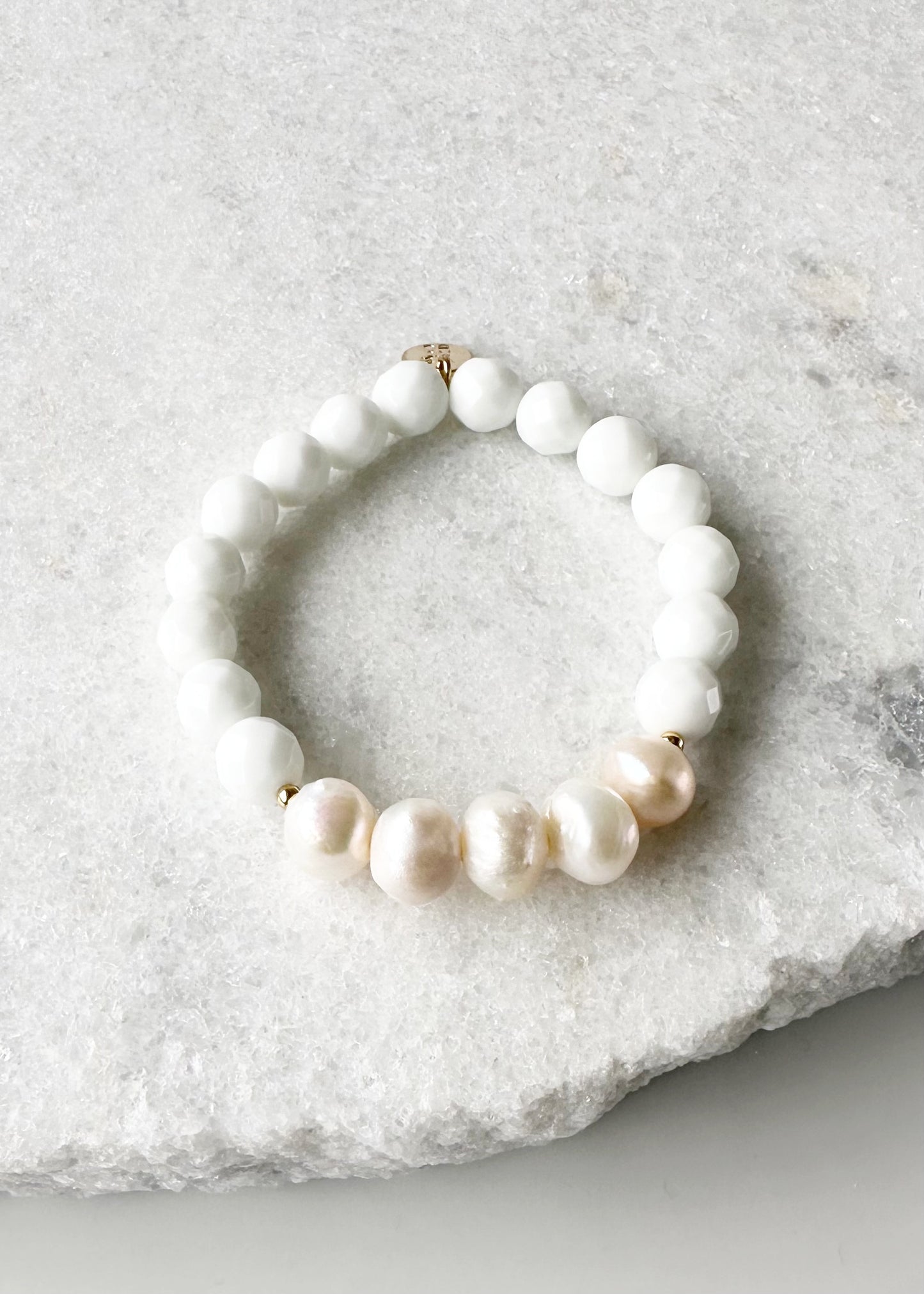 Five Large White Baroque Freshwater Pearls Accompanied by White Semi-Precious Stones (10 mm) with Gold accents in this 7” Stretch Bracelet.