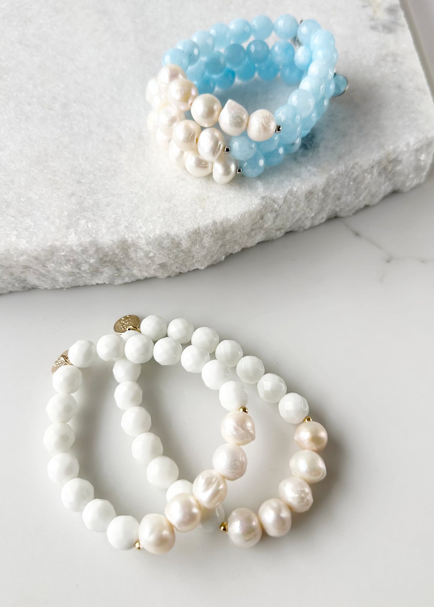 Five Large White Baroque Freshwater Pearls Accompanied by White or Light Blue Semi-Precious Stones (10 mm) with Silver or Gold accents in this 7” Stretch Bracelet. Both Shown