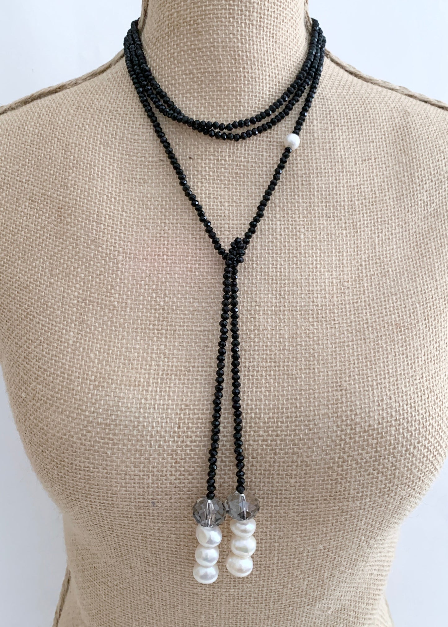 Long, 64-inch Lariat-Style Necklace with Black Crystals and White Freshwater Pearls.  This Versatile piece allows it to be worn in many ways. Shown on Bust in Different Style