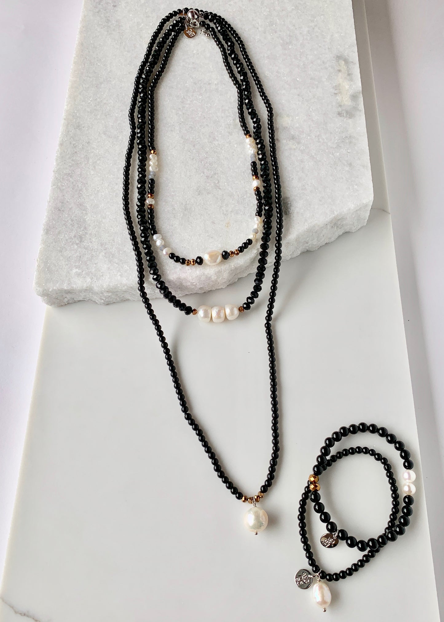 Simple and Elegant, a Large Freshwater Pearl Drop on this Black Agate Necklace with Gold Accents. Can be worn on its own or Stacked with other Necklaces. Shown with Complementary Bracelets and Necklaces.