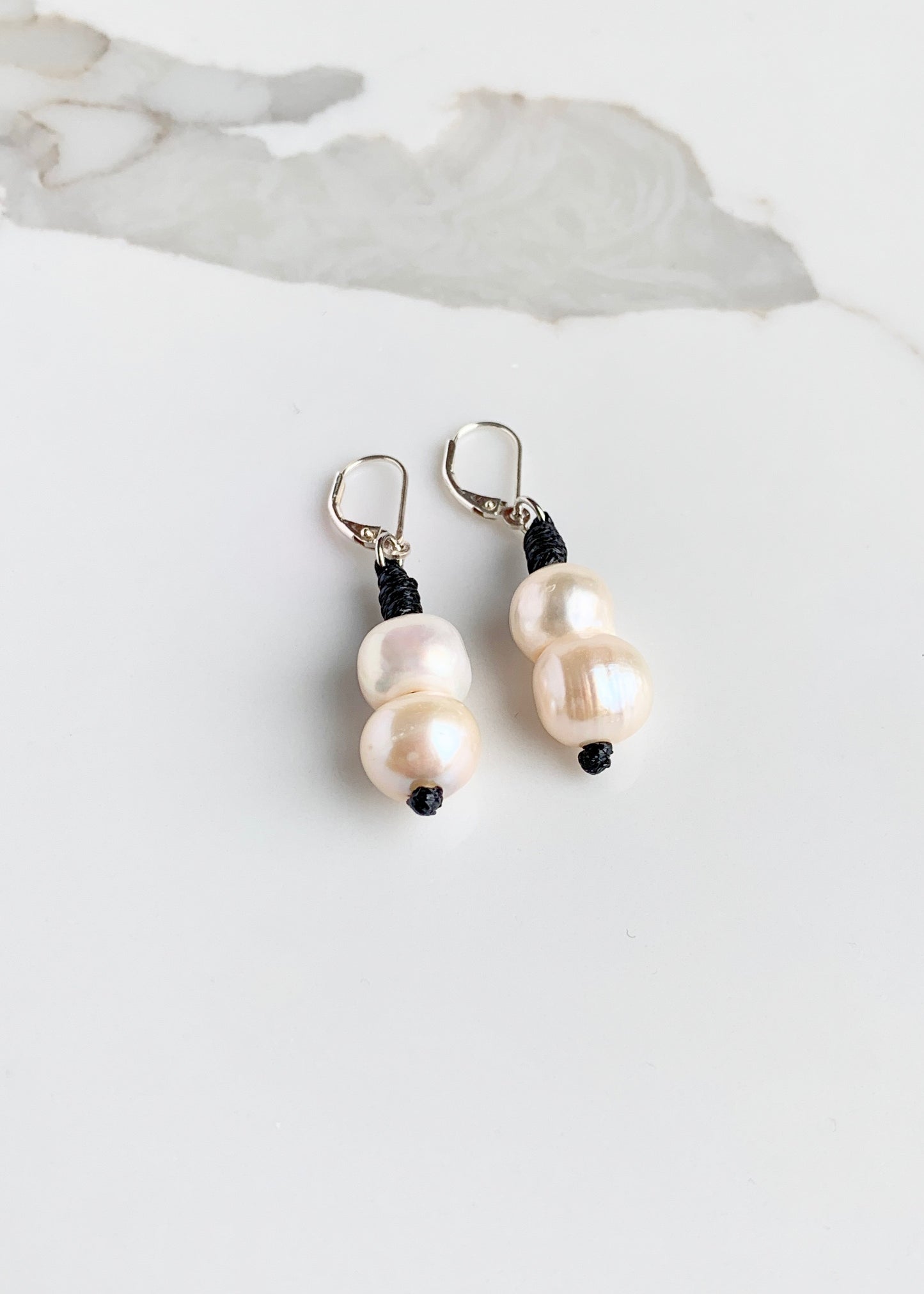 Two White Freshwater Pearls on a Sterling Siler Lever Back with Black accent. Magnified to show Lustre.