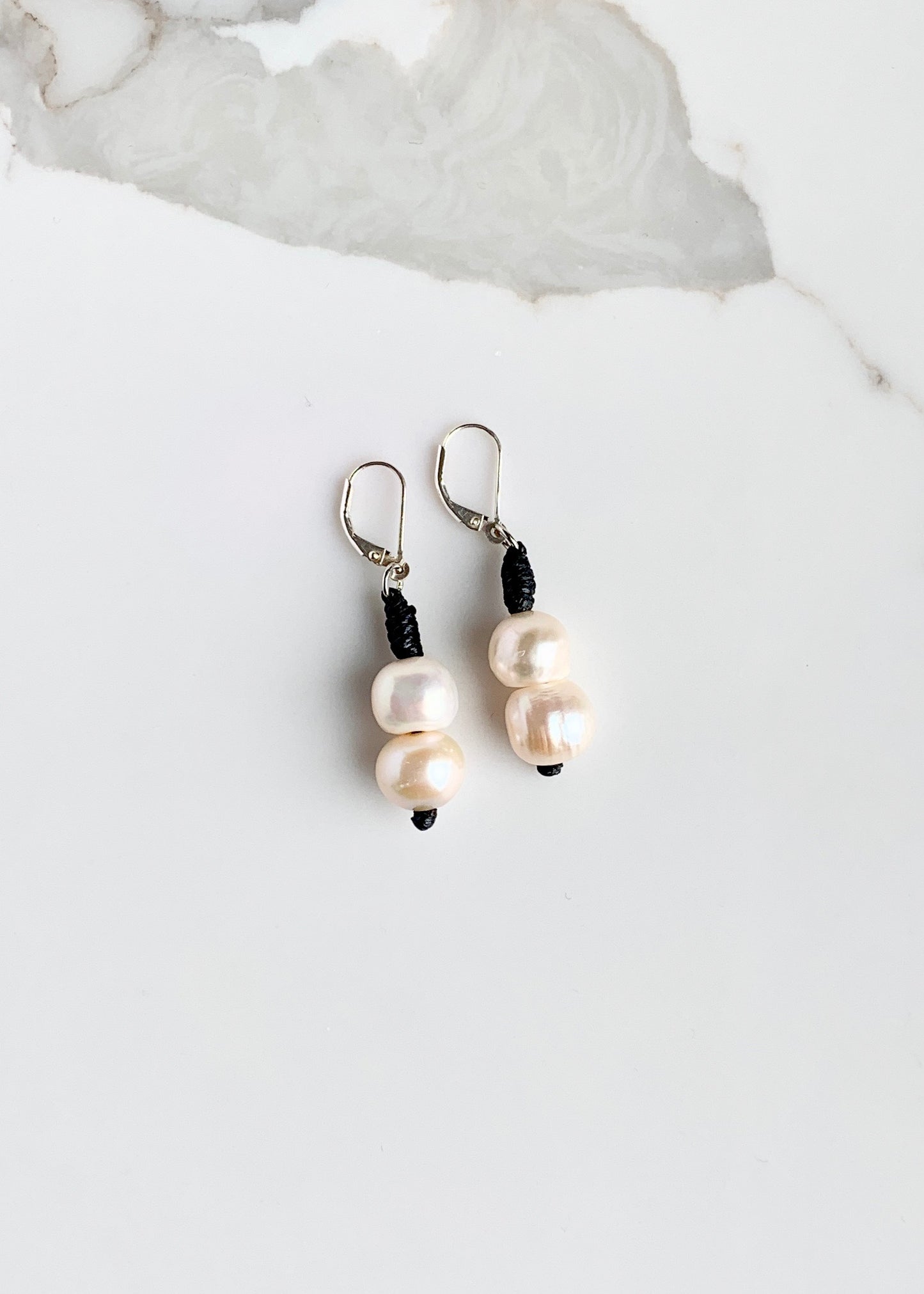 Two White Freshwater Pearls on a Sterling Siler Lever Back with Black accent.