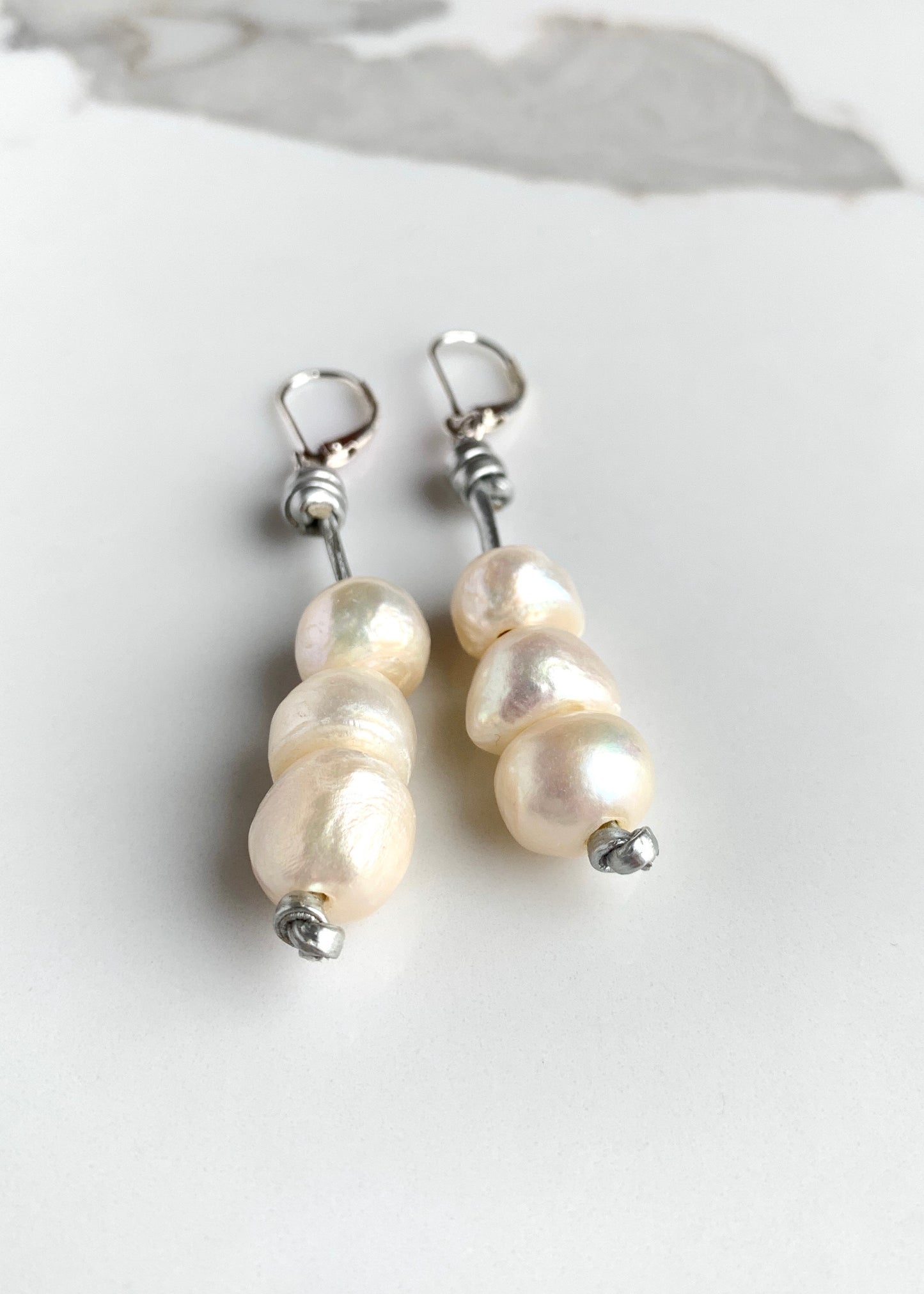 Three Stacked White Freshwater Pearls on Silver Thread with Sterling Silver Leverbacks. Magnified to show Lustre.