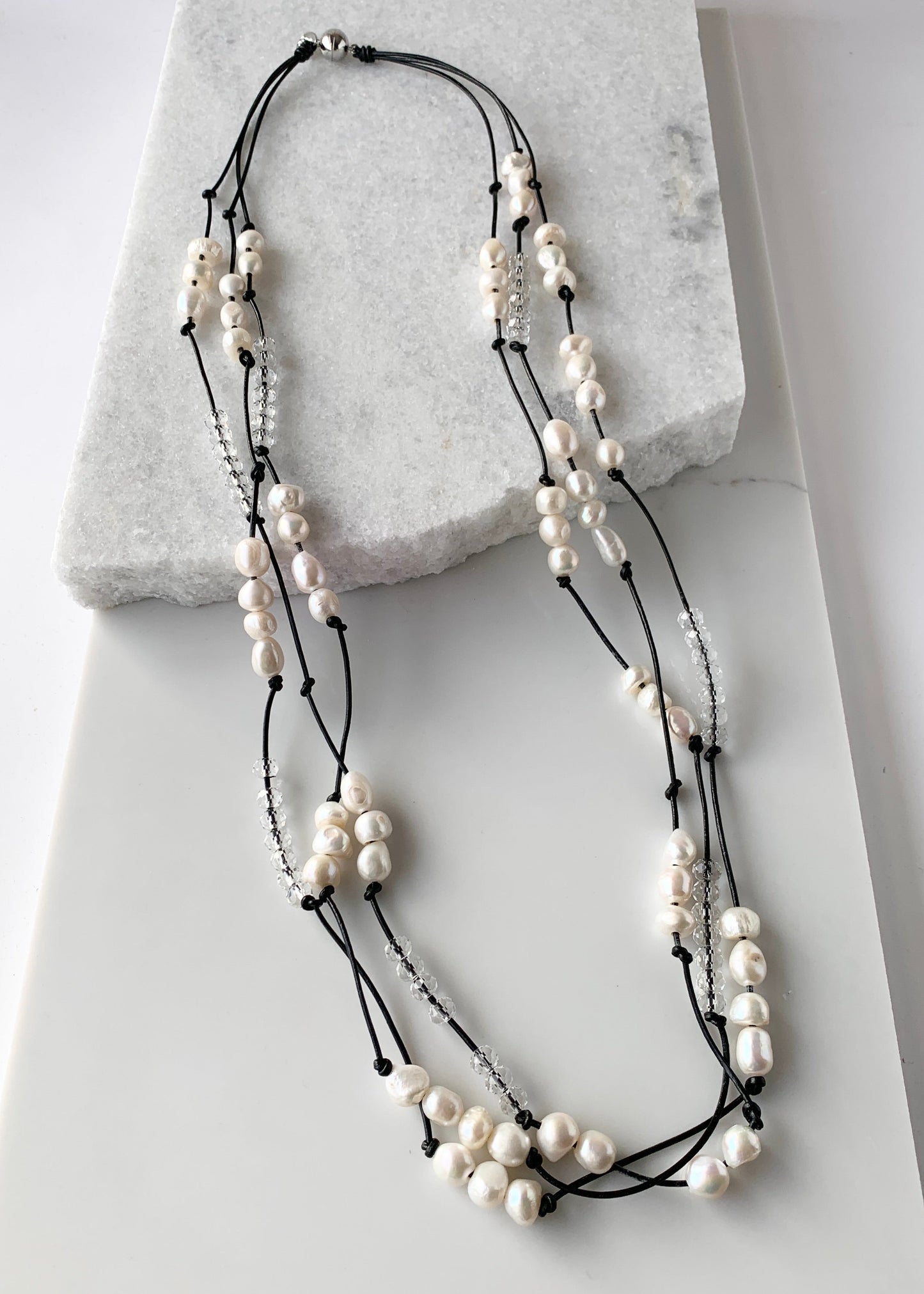 White Baroques Freshwater Pearls and White Faceted Crystals on Black Knotted Leather For a Long  39” Necklace with Strong Secure Magnetic Clasp for Easy Wear.