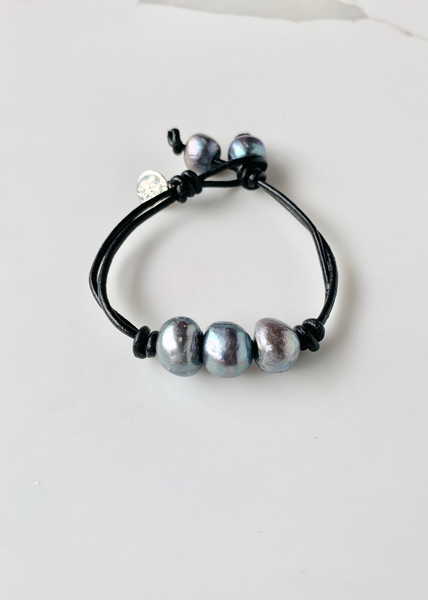 Black Leather Bracelet Highlighting Three Black Baroque Freshwater Pearls with a Separate Pearl and Loop Closure. Can be worn Separately or Layered with other Bracelets.
