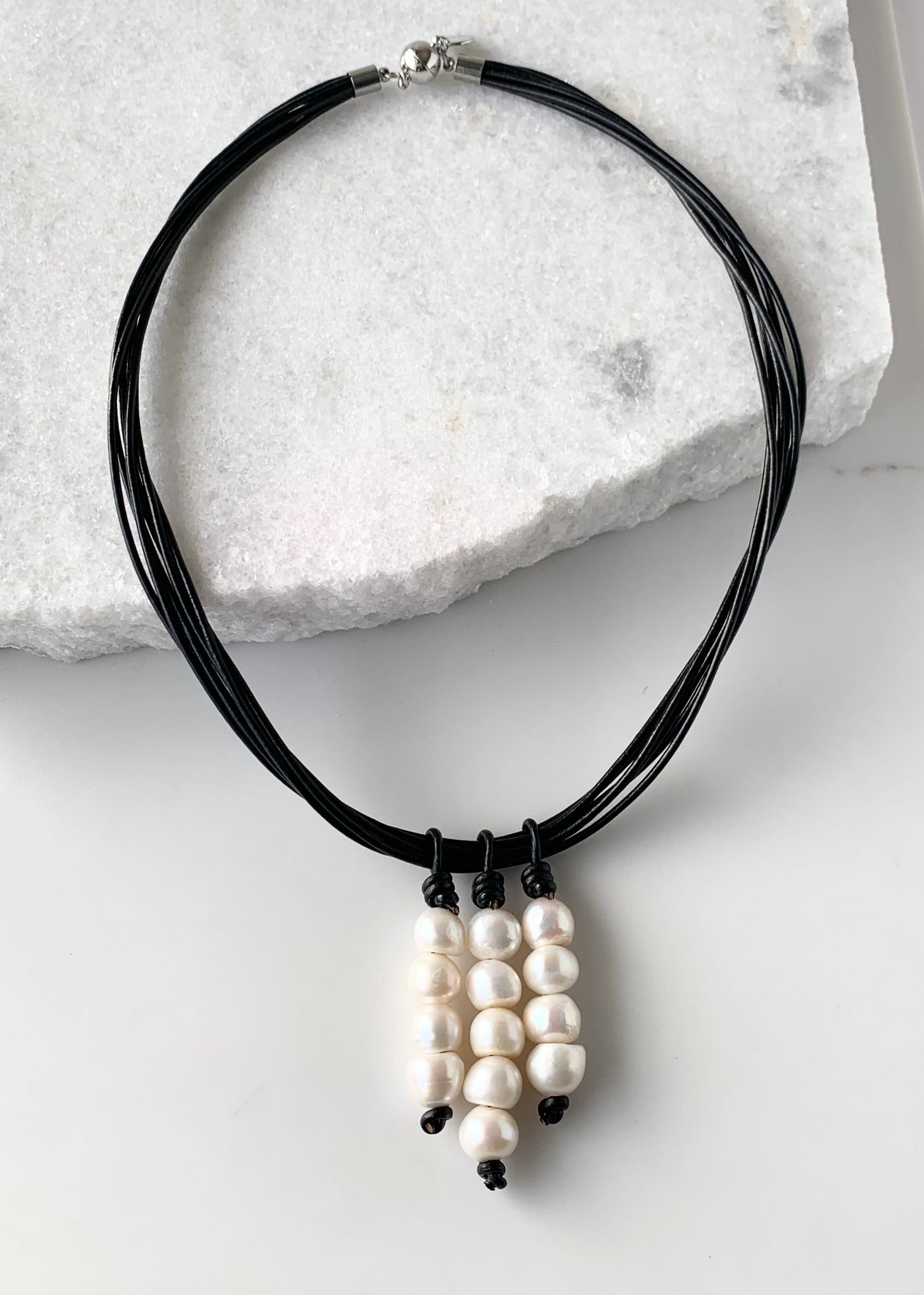 Three Stacks of White Baroque Freshwater Pearls on Black Leather Cord Make Up this Necklace with a Strong Secure Magnetic Clasp for Easy Wear.