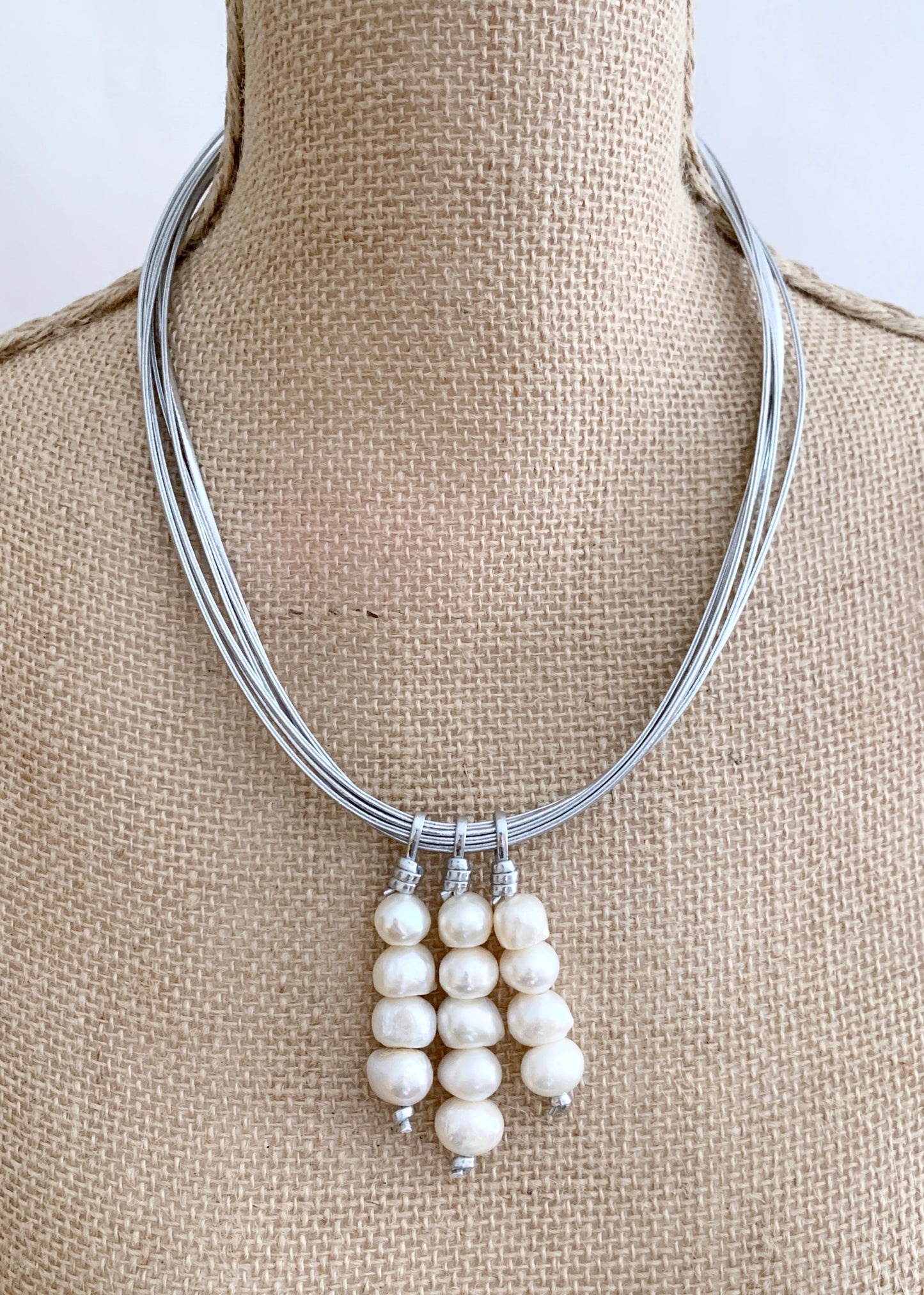 Three Stacks of White Baroque Freshwater Pearls on Silver Metal Cord Make Up this Necklace with a Strong Secure Magnetic Clasp for Easy Wear. On Bust