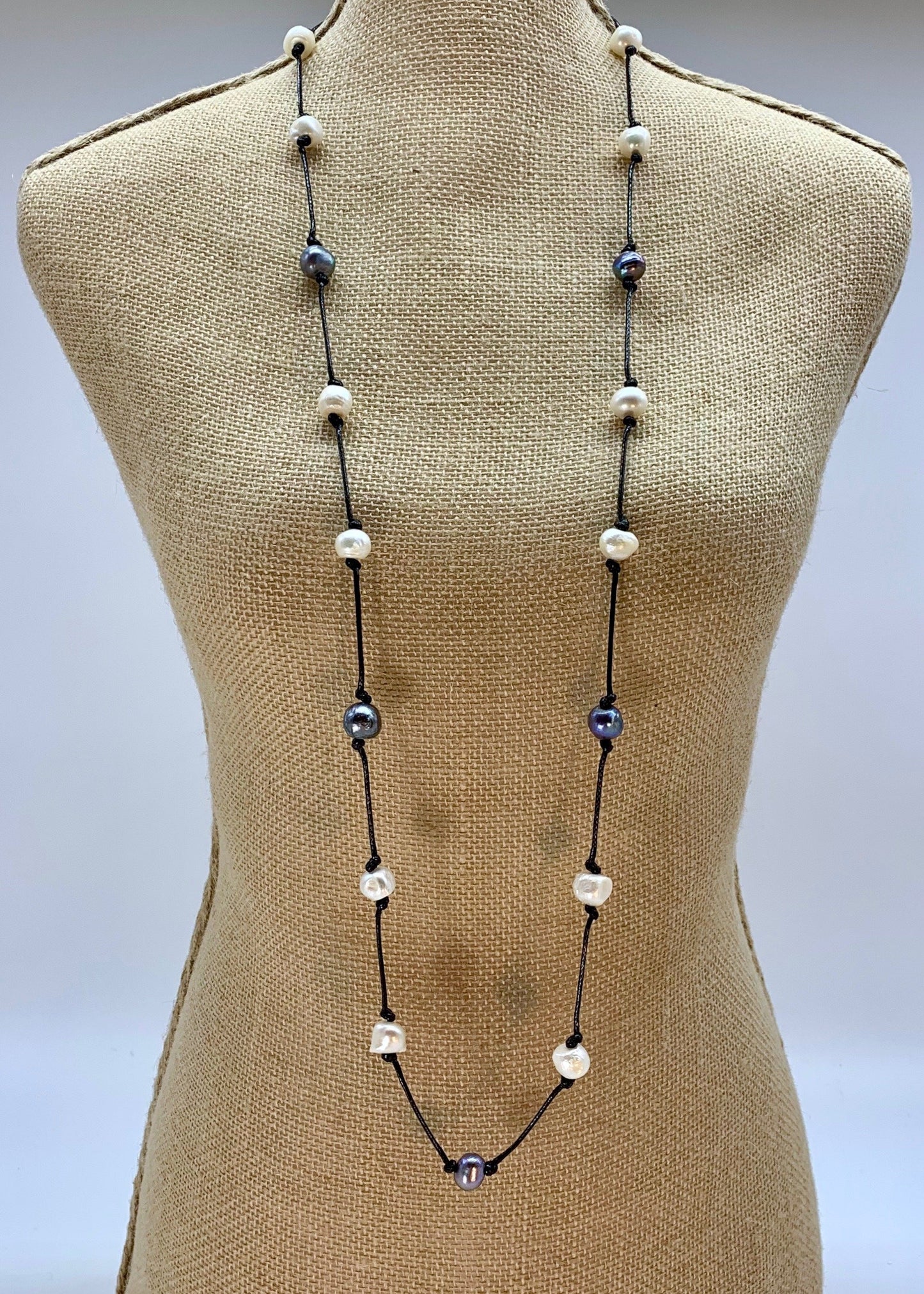 Lustrous White and Silver Freshwater Pearls Knotted on Blue Cotton in this 21” Necklace. On Bust