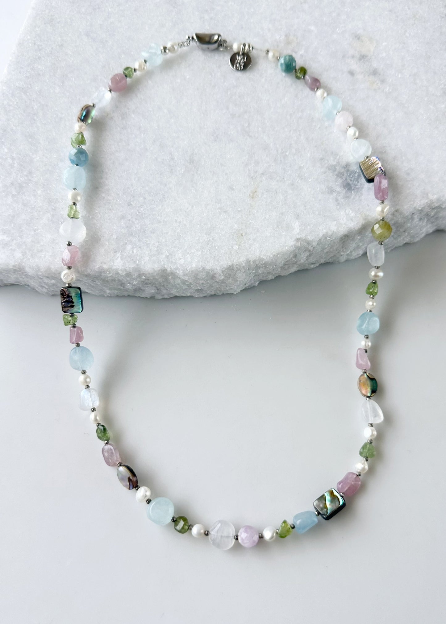 Designed and made in Canada, this Beautiful One-Of-A-Kind 22.5” Necklace has a Mix of Aquamarine, Moonstone, Peridot, Rose Quartz, Morganite, Shell Beads and White Pearls accented with Tiny Pyrite Beads and finished with a Bean Clasp.