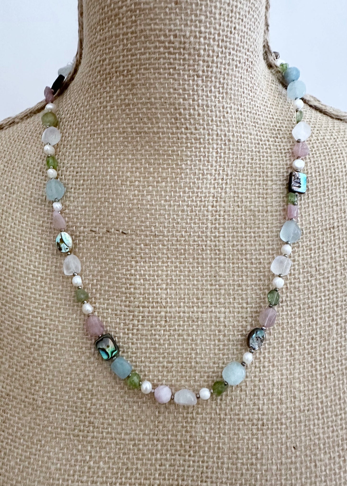 Designed and made in Canada, this Beautiful One-Of-A-Kind 22.5” Necklace has a Mix of Aquamarine, Moonstone, Peridot, Rose Quartz, Morganite, Shell Beads and White Pearls accented with Tiny Pyrite Beads and finished with a Bean Clasp.