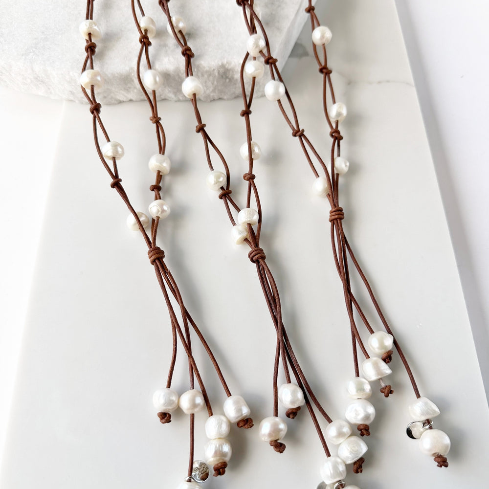 
                      
                        Three White Freshwater Pearl Necklaces on Tan Leather
                      
                    