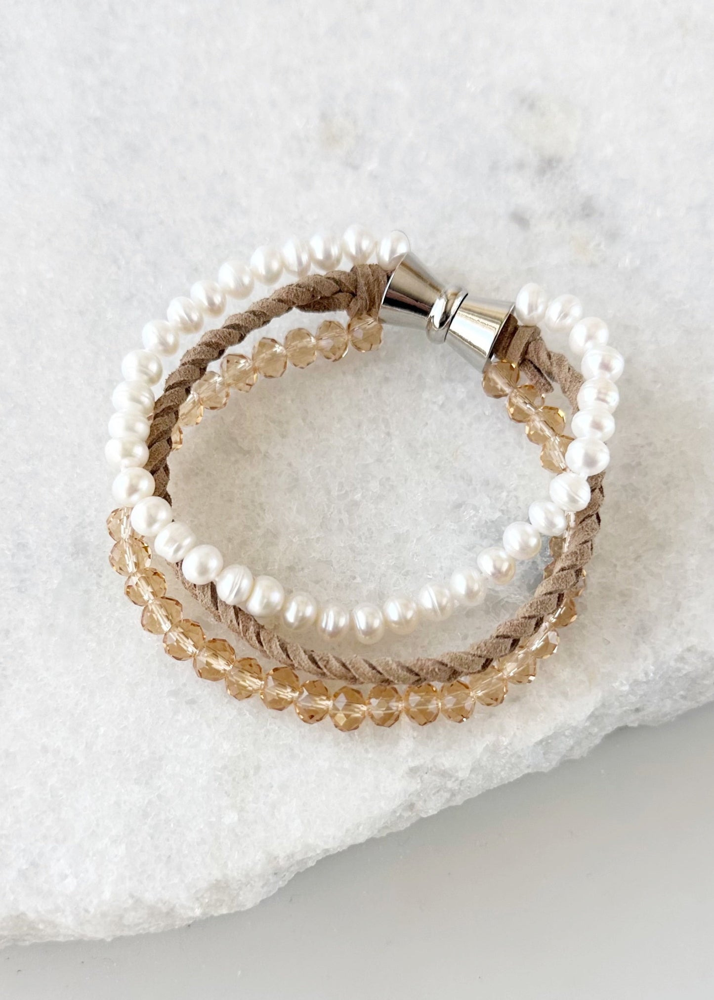 Designed in Canada, the 7.5” Blair Bracelet Features Three Strands of Coordinating Shades of Braided Suede, 6mm Crystal and White Freshwater 6mm Pearls and finished with a Magnetic Clasp for Easy Wear. The Blair Bracelet coordinates with the Carly Necklace and Cora Earring.