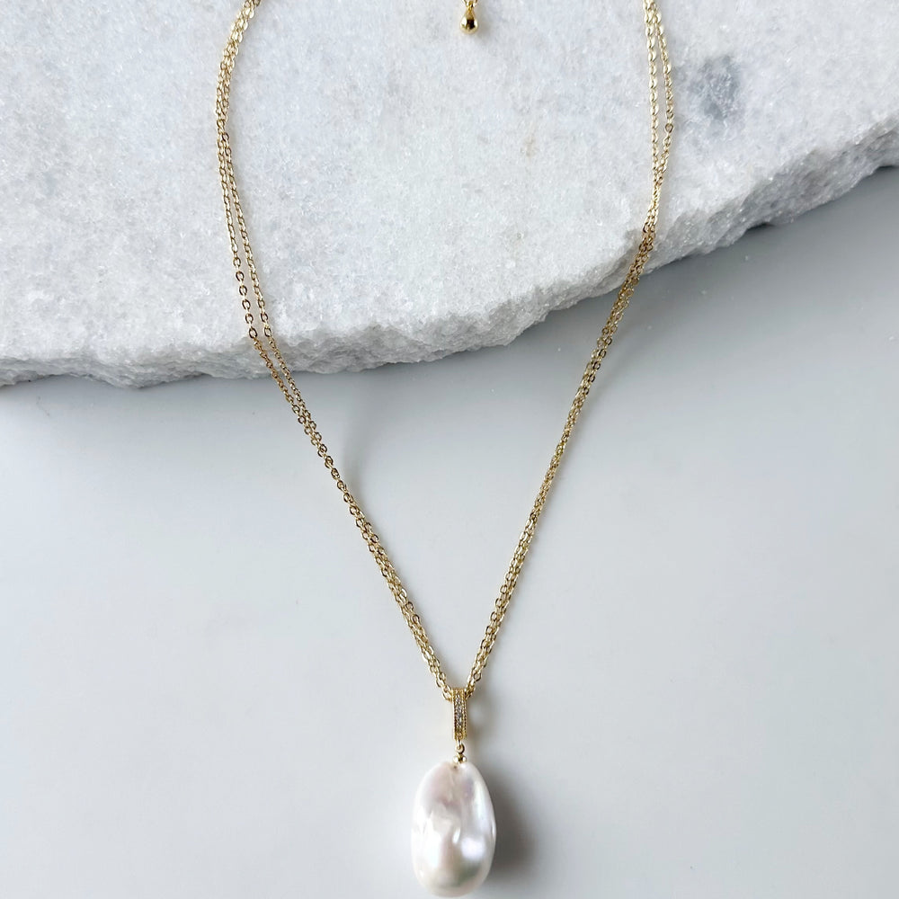 
                      
                        Large Baroque White Freshwater Pearl Pendant on Gold-Plated Bail with In-Laid Cubic Zirconia.  This Clip-On Pendant allows you to wear it with many of your favorite Pearl Necklaces. Here, shown on Gold-Plated Chain.
                      
                    