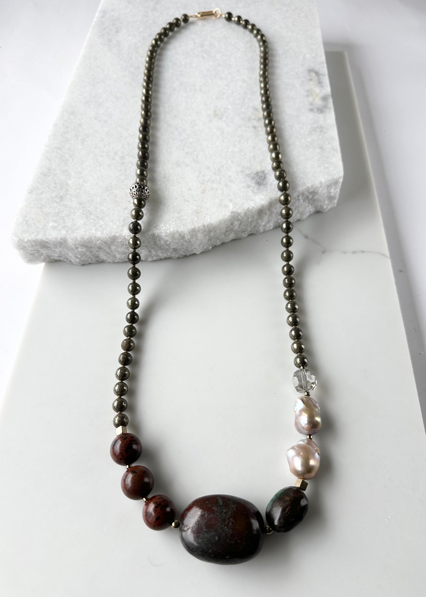 This Unique Long (40”) Necklace Features a combination of Brown Turquoise, Mahogany Obsidian, Pyrite, Crystal, Baroque Freshwater Pearls, finished with Silver and Gold Accents and a Charm Clasp. Wear it Long or Double it up!